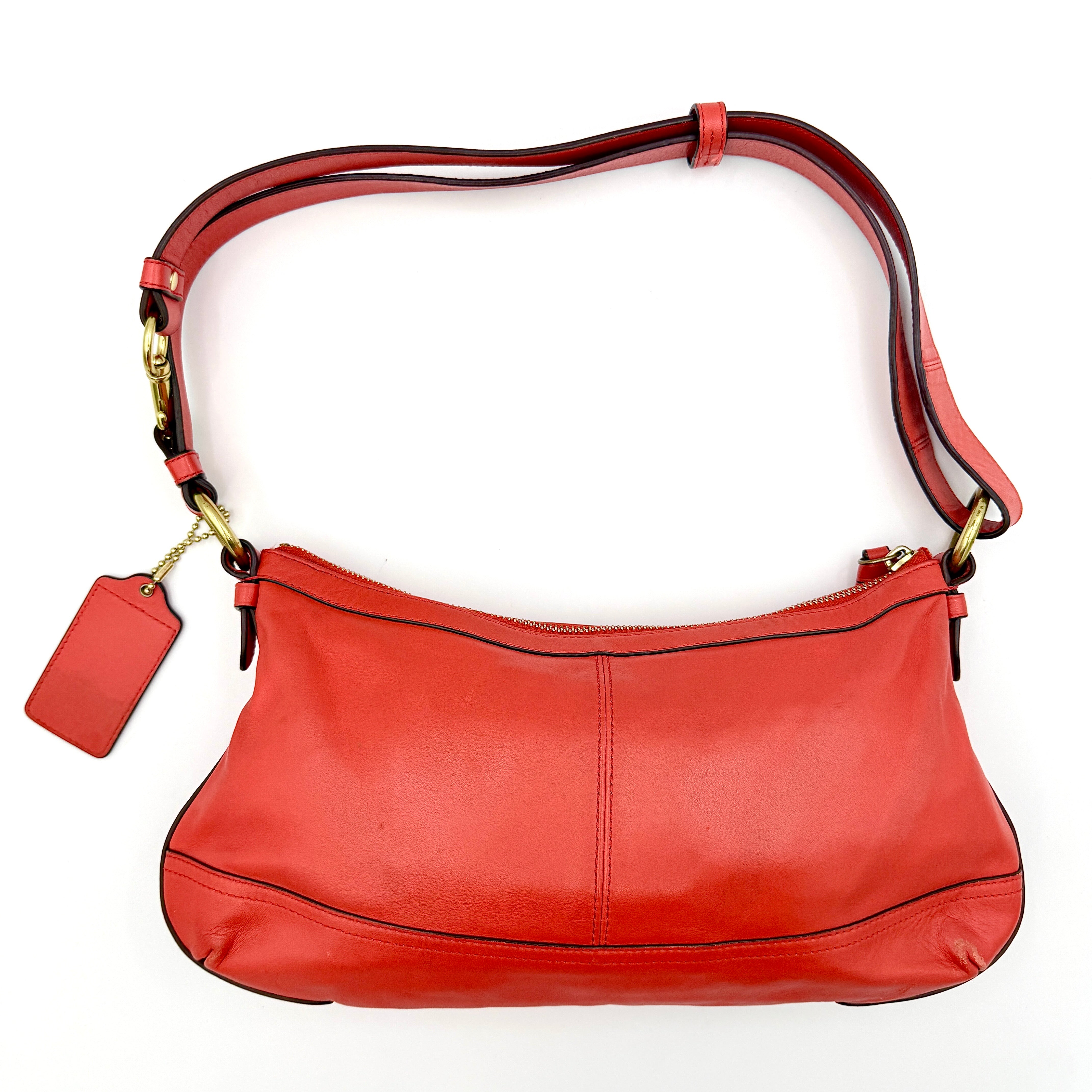 Coach 2Way Park Shoulder Bag in orange leather with gold hardware and adjustable strap, displayed against a white background.