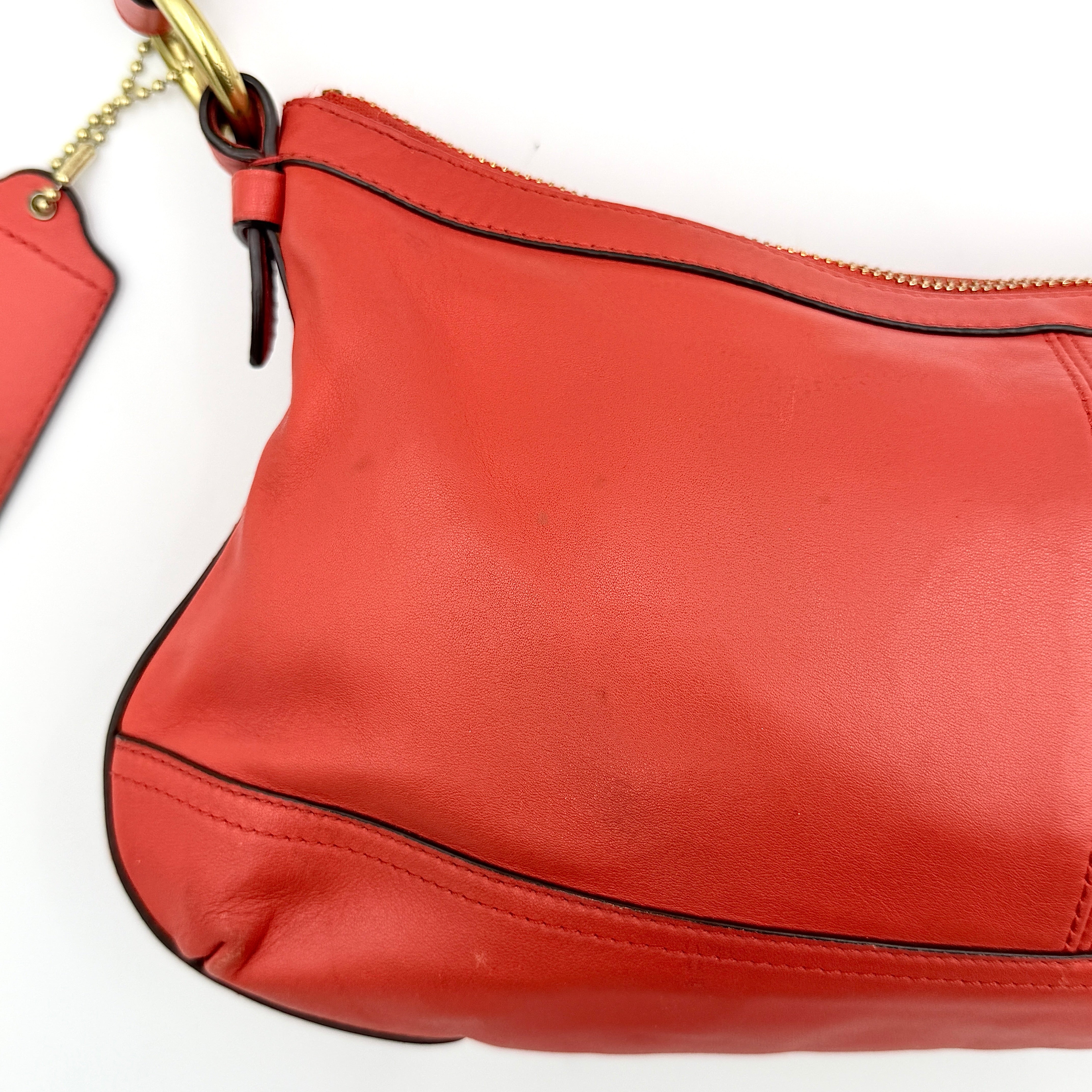 Coach 2Way Park Shoulder Bag in orange leather with gold hardware and adjustable strap, displayed against a white background.