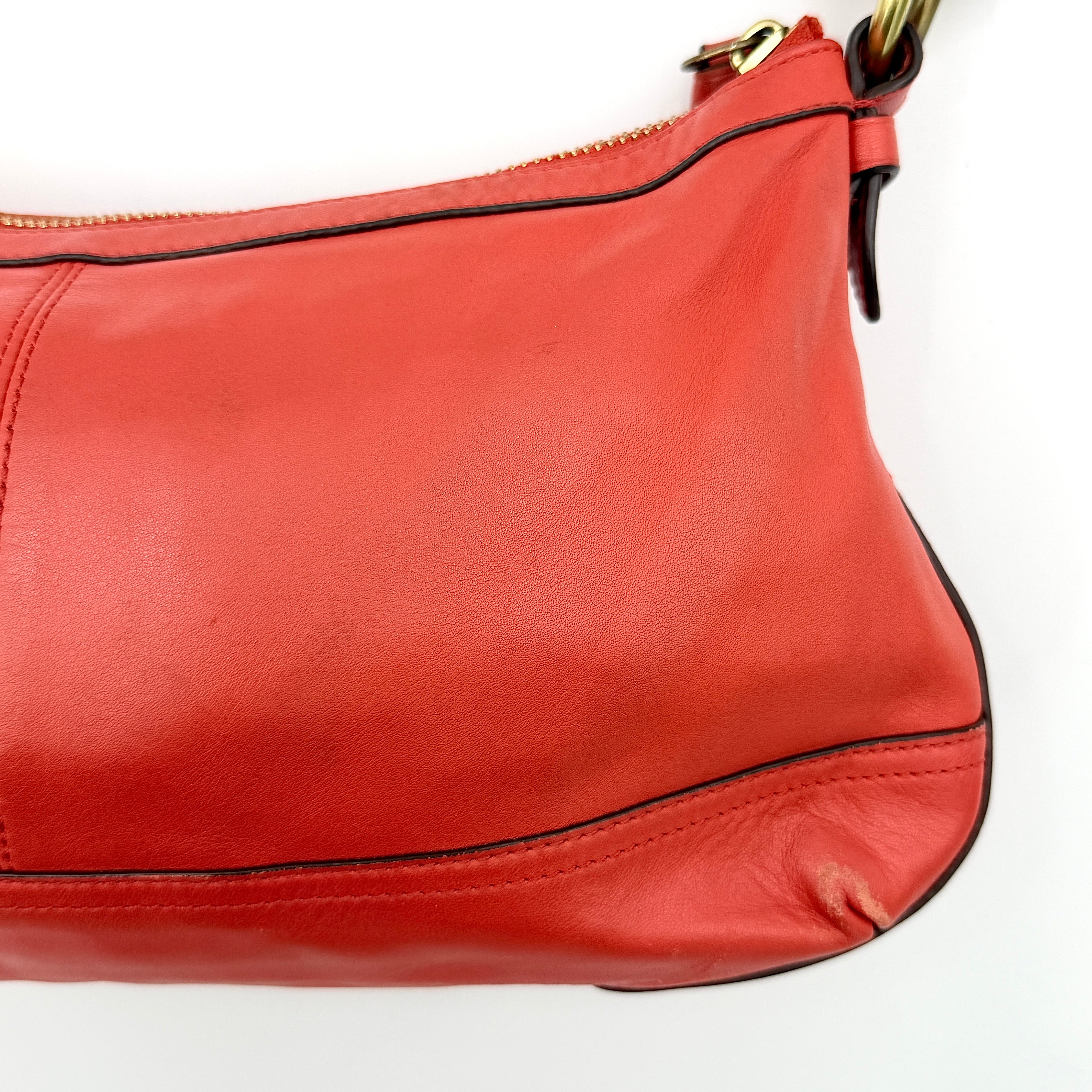 Coach 2Way Park Shoulder Bag in orange leather with gold hardware and adjustable strap, displayed against a white background.