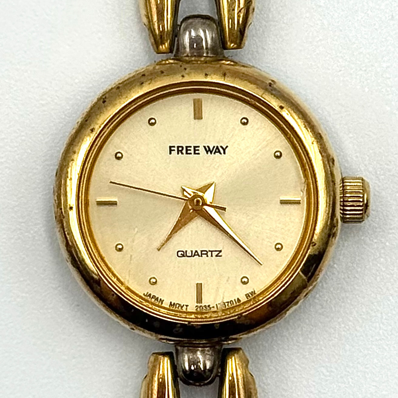 Citizen Free Way two-tone quartz watch with gold and silver link bracelet displayed on a black cushion.