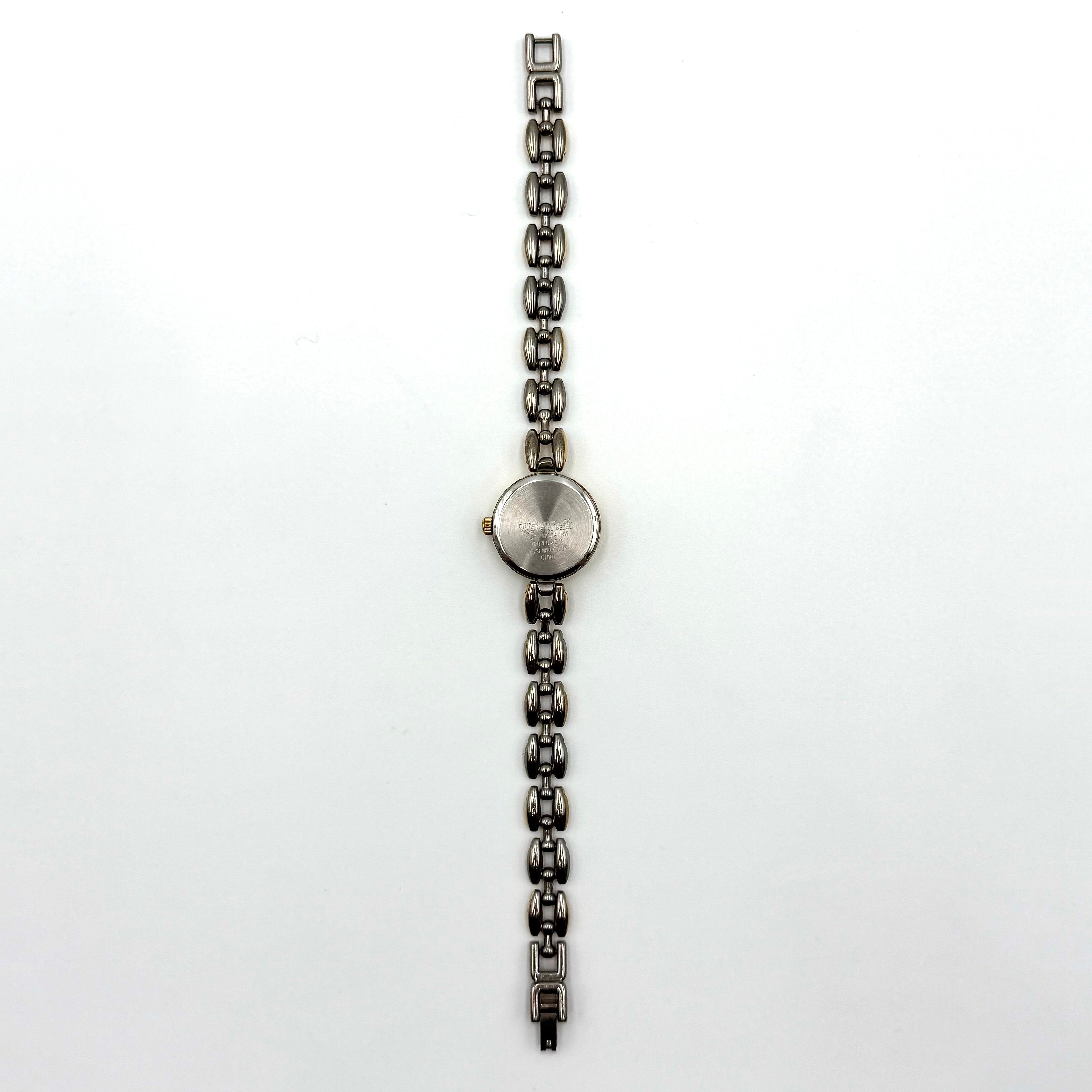 Citizen Free Way two-tone quartz watch with gold and silver link bracelet displayed on a black cushion.
