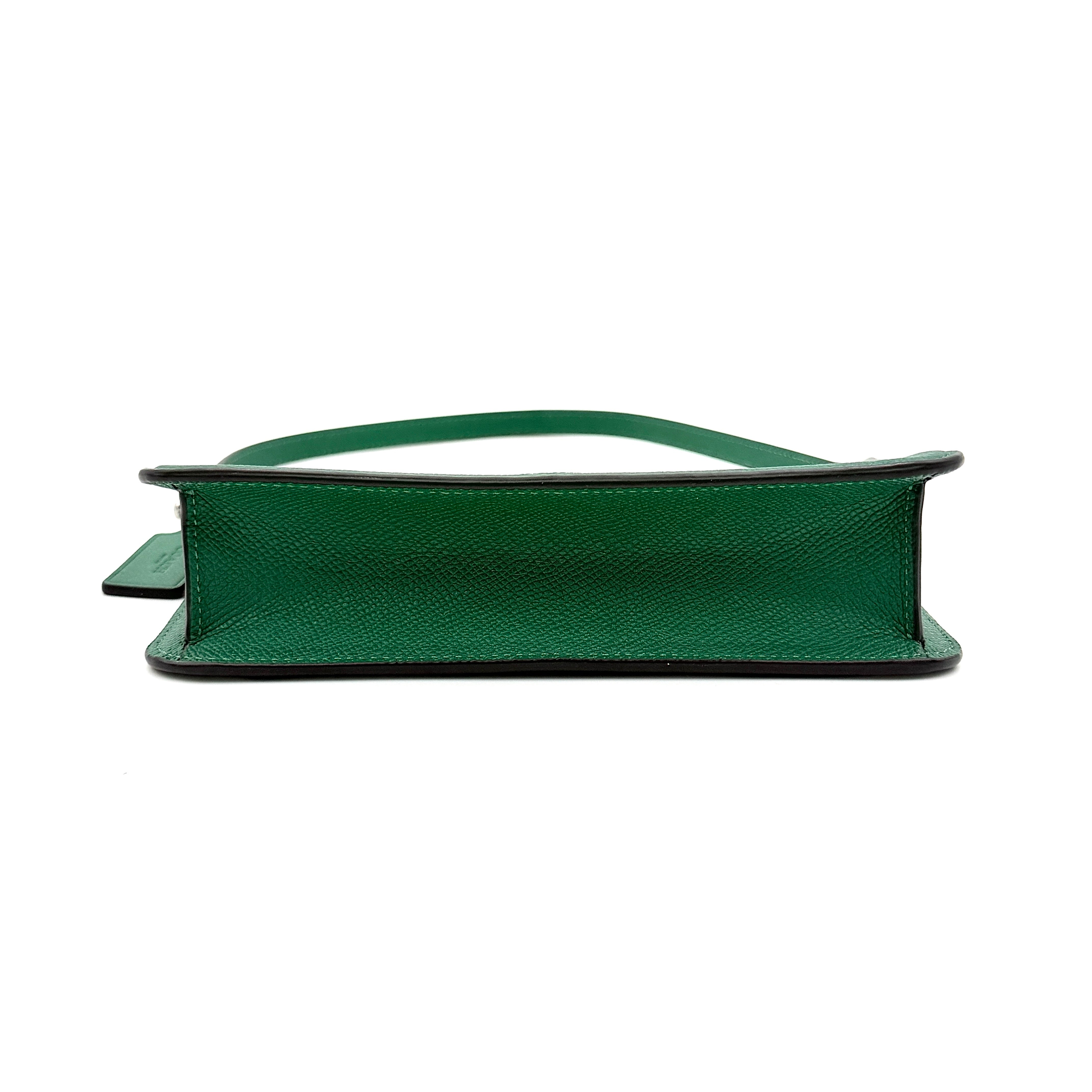 Coach green grained leather shoulder bag with silver C plaque and top zip, styled with a short strap.