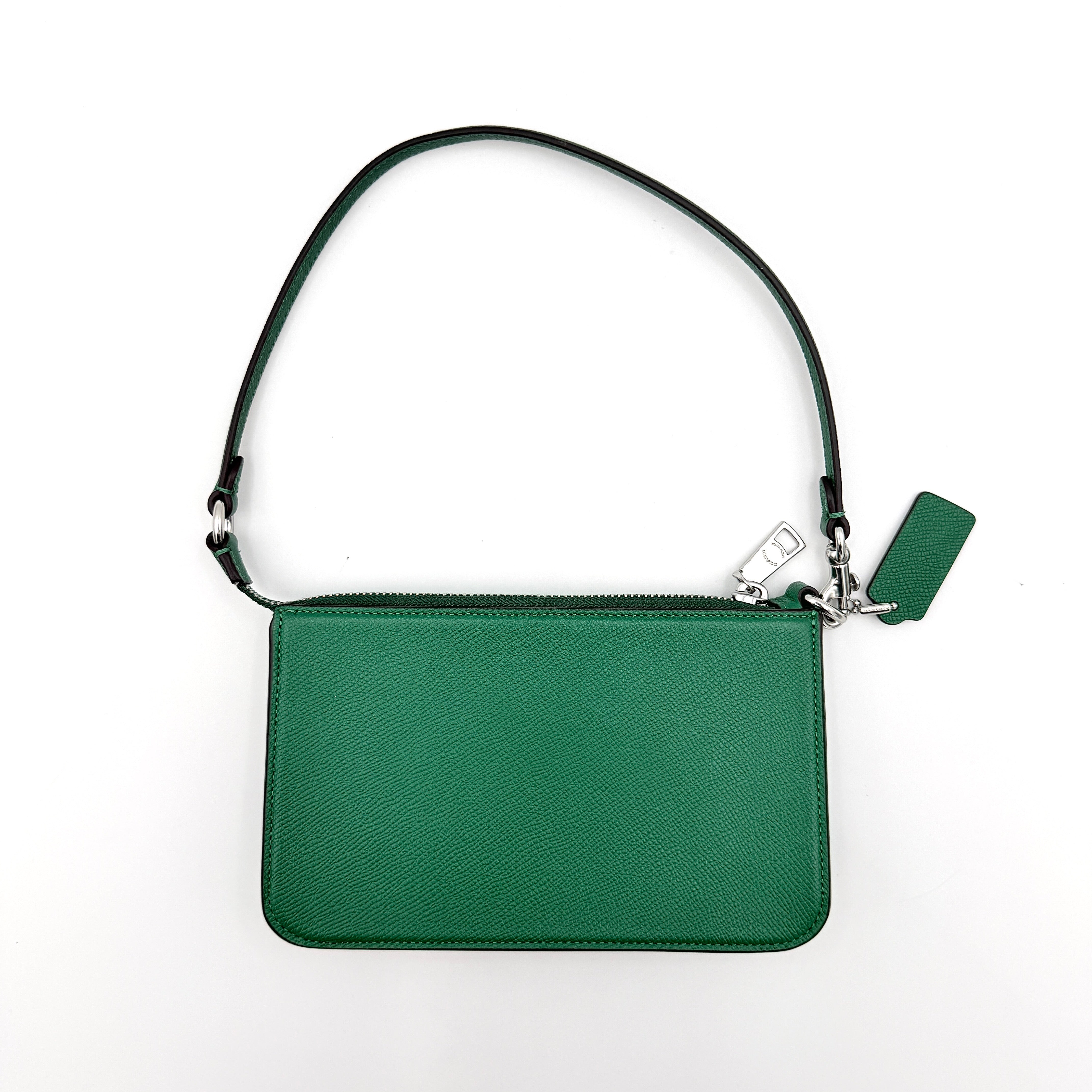 Coach green grained leather shoulder bag with silver C plaque and top zip, styled with a short strap.