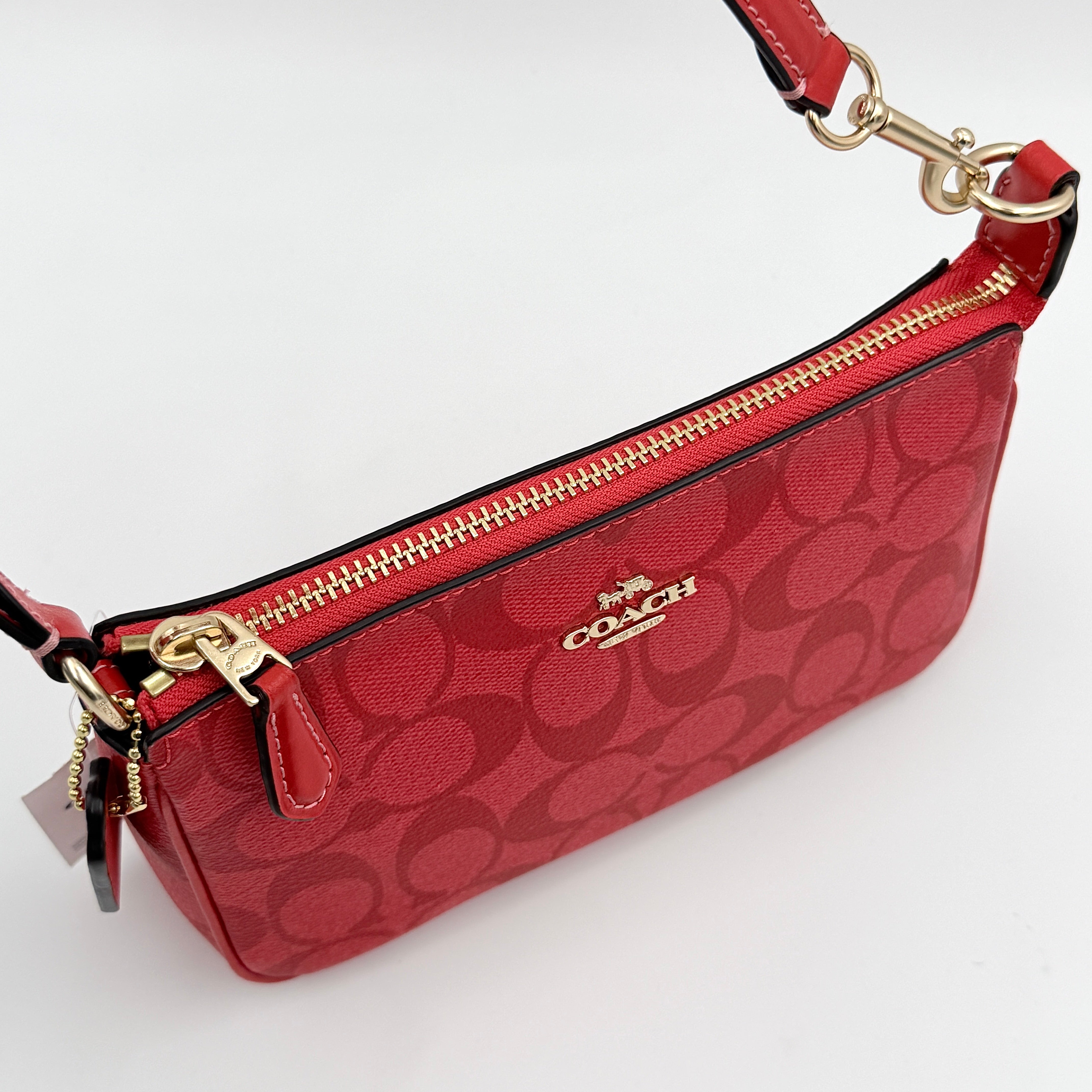 Coach Signature Nolita 19 Shoulder Bag in bright red coated canvas with signature pattern, gold-tone hardware and matching red hangtag.