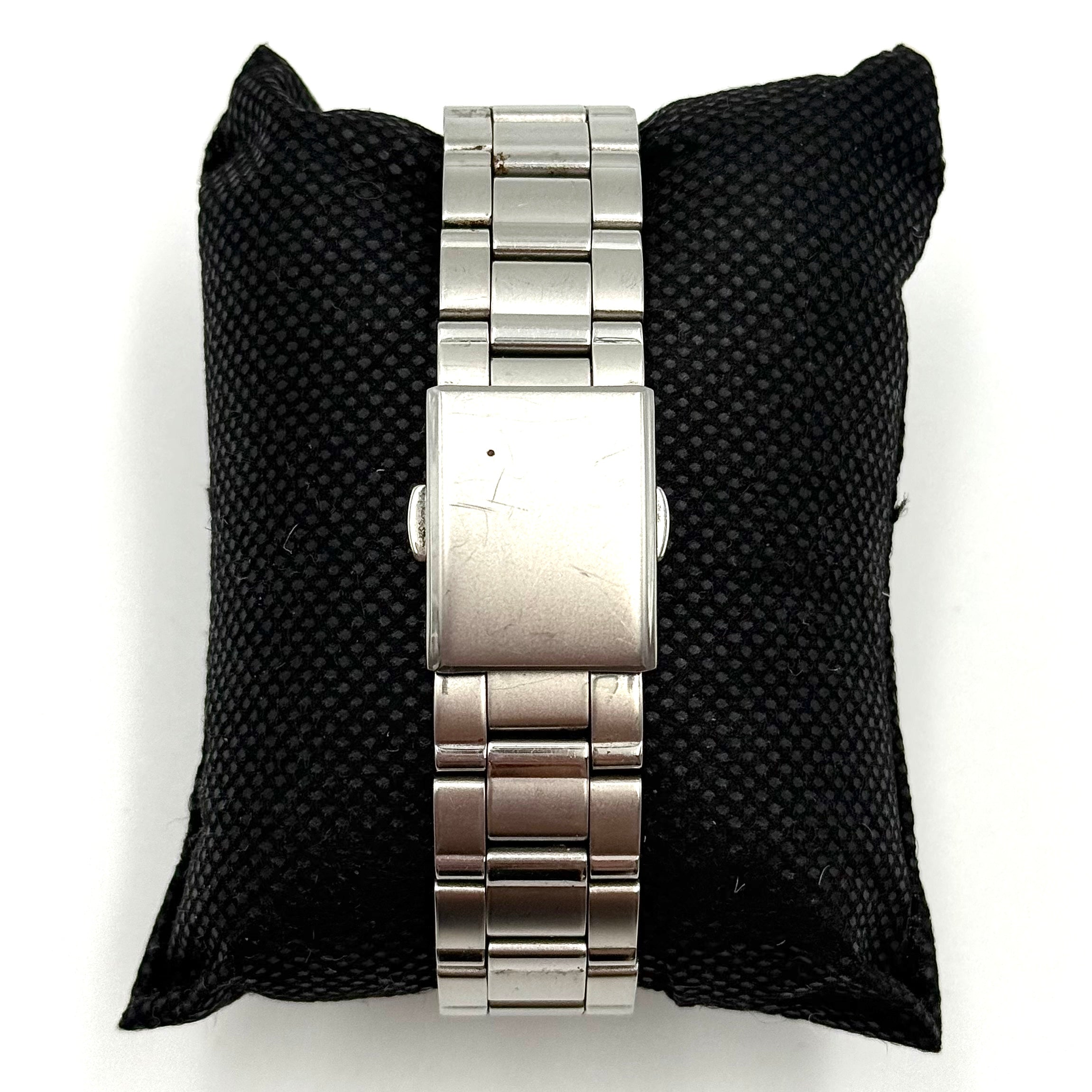 Seiko Spirit 7N93-7000 Quartz Watch in silver with a white textured dial and stainless steel bracelet, shown on a black cushion.