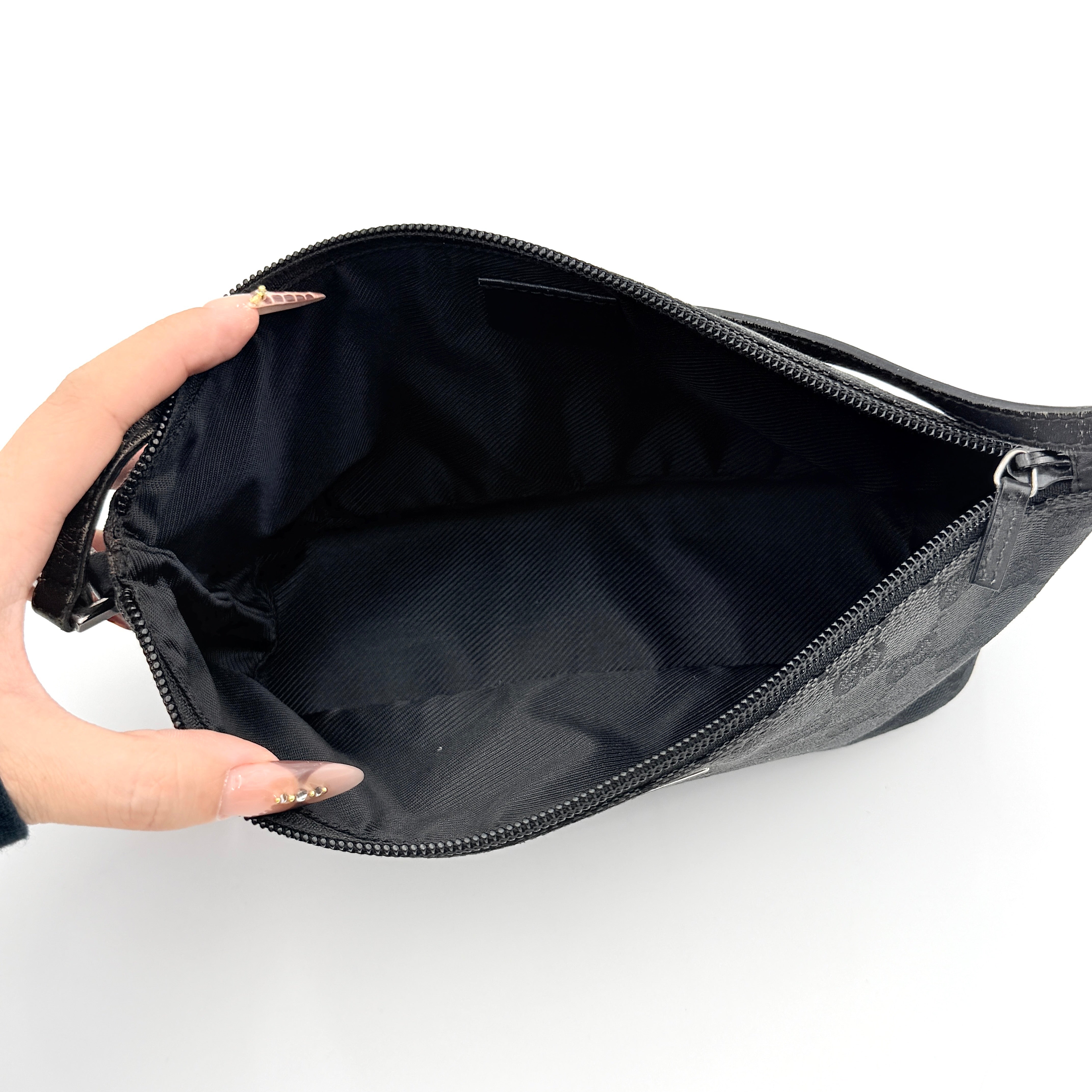 The Gucci GG Monogram Pochette Boat Shoulder Bag in black canvas with leather trim and silver-tone hardware, shown from the front with its structured, compact shape.