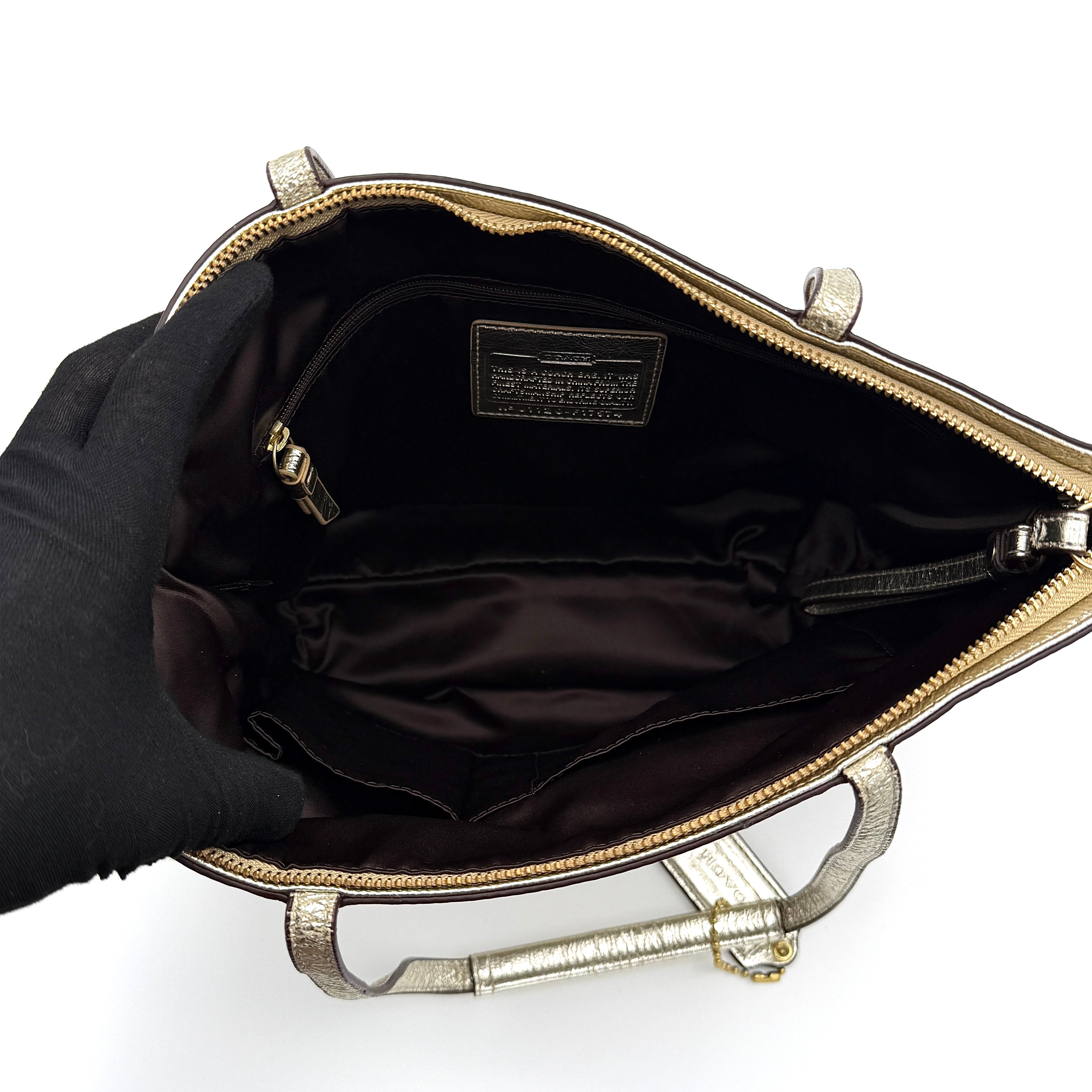 Coach Signature Stripe Tote Bag in gold and beige canvas with metallic gold leather trim and double handles.
