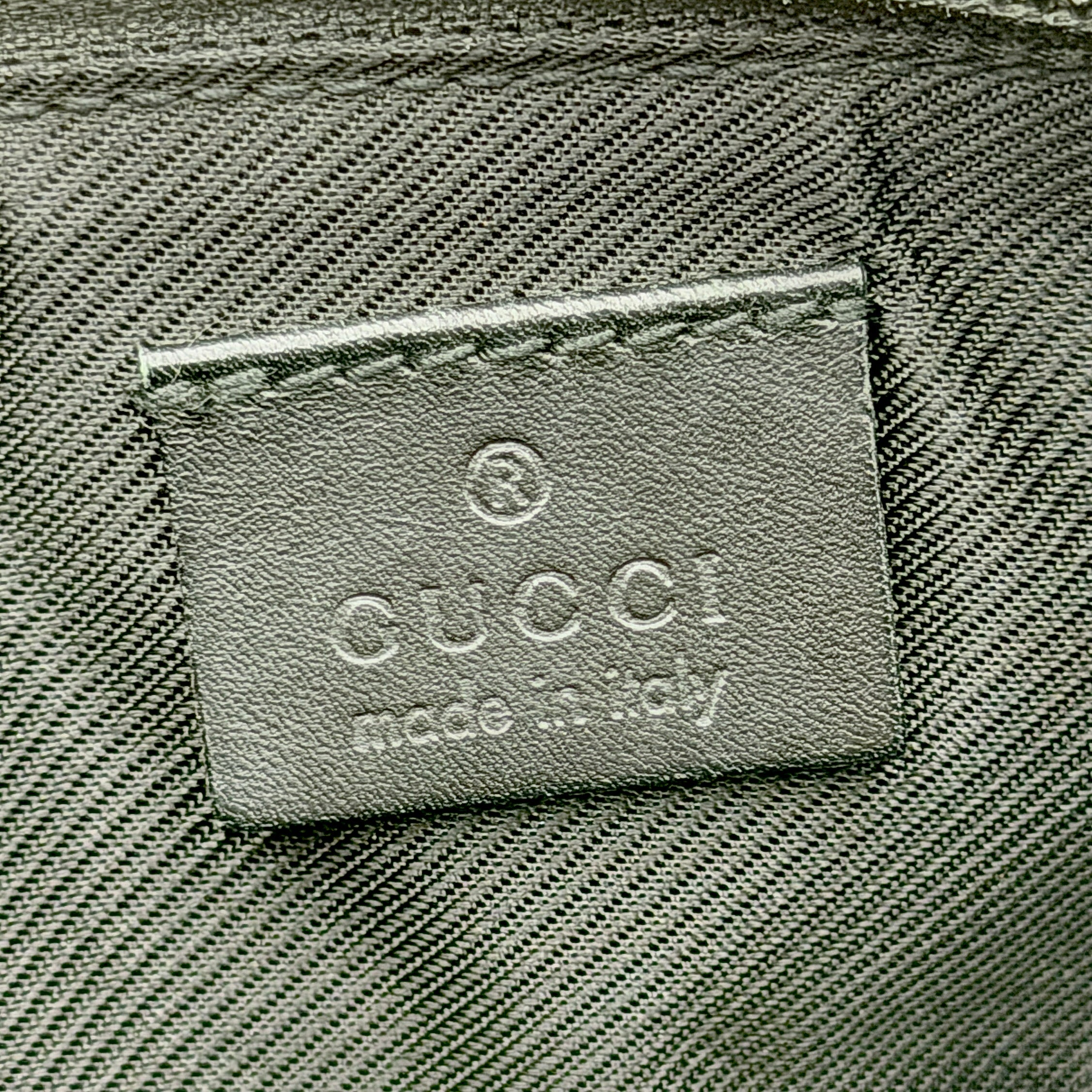 The Gucci GG Monogram Pochette Boat Shoulder Bag in black canvas with leather trim and silver-tone hardware, shown from the front with its structured, compact shape.