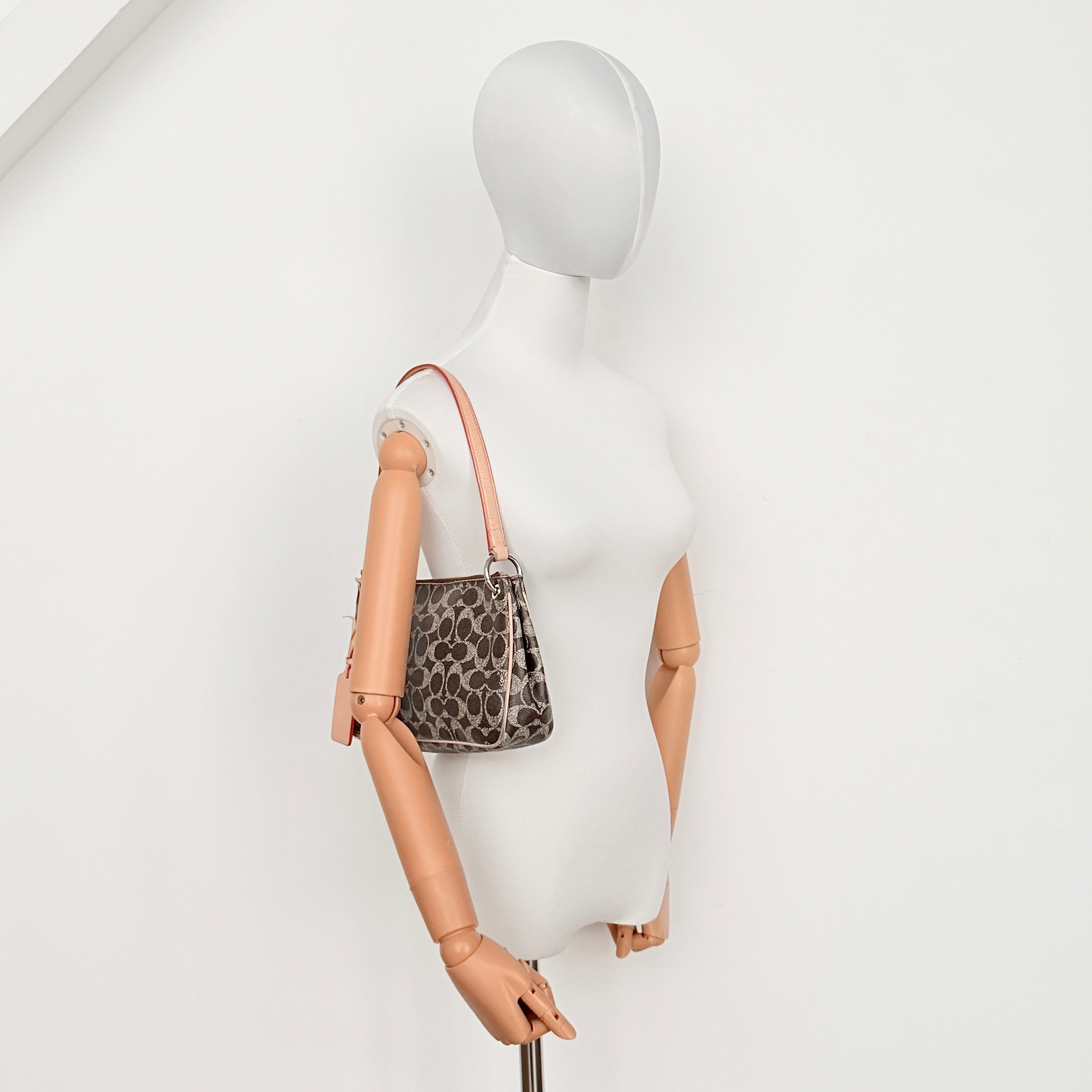 Coach Signature Charley Shoulder Bag in grey and beige canvas with monogram print, tan leather trim, and a single leather strap.