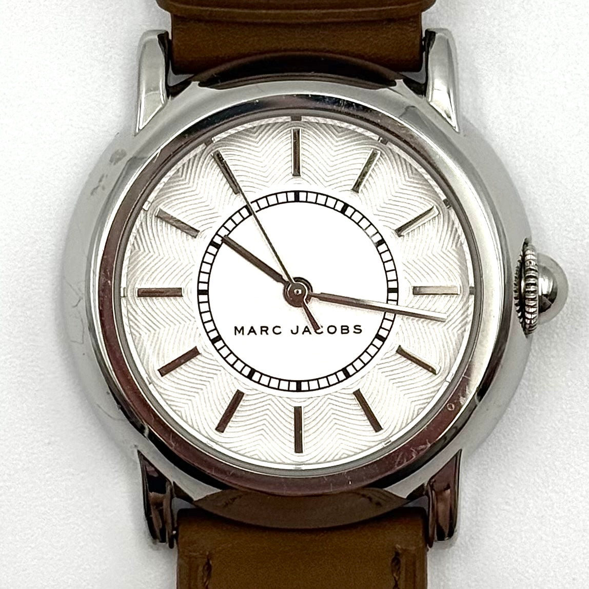 Marc Jacobs Courtney watch with silver stainless steel case and brown leather strap shown on a black cushion.
