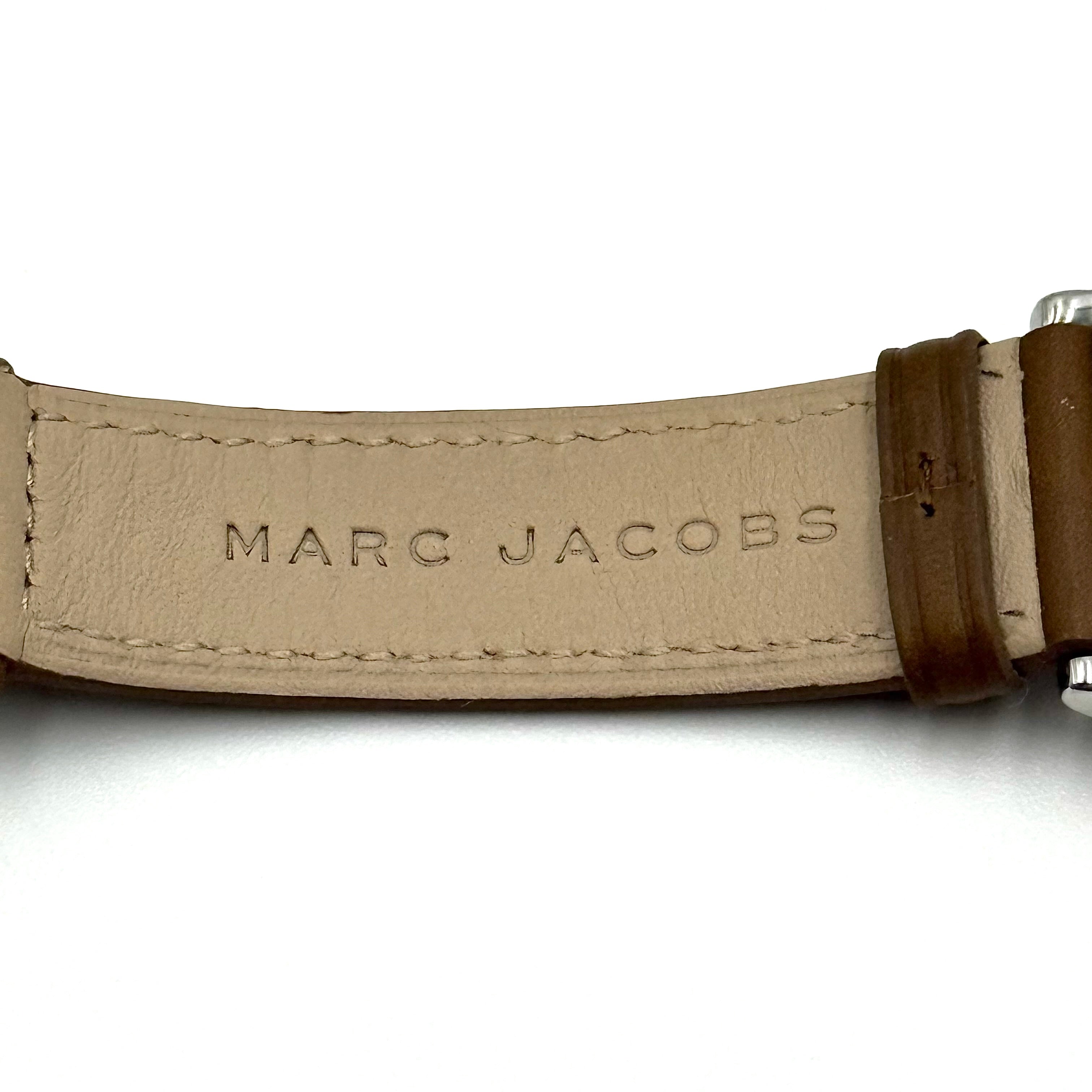 Marc Jacobs Courtney watch with silver stainless steel case and brown leather strap shown on a black cushion.