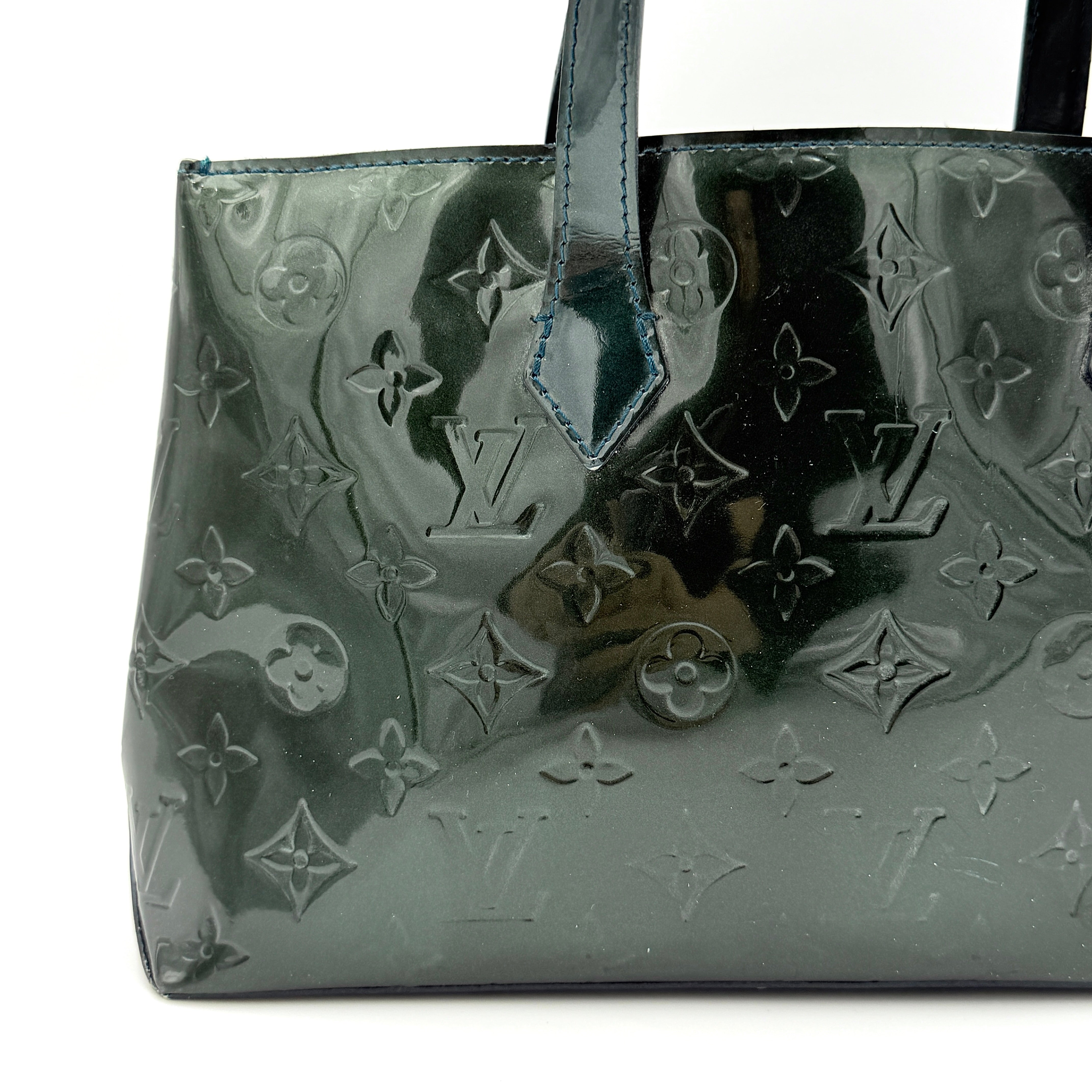 Louis Vuitton Wilshire PM bag in glossy dark green Monogram Vernis patent leather, shown with double top handles and gold-tone nameplate.