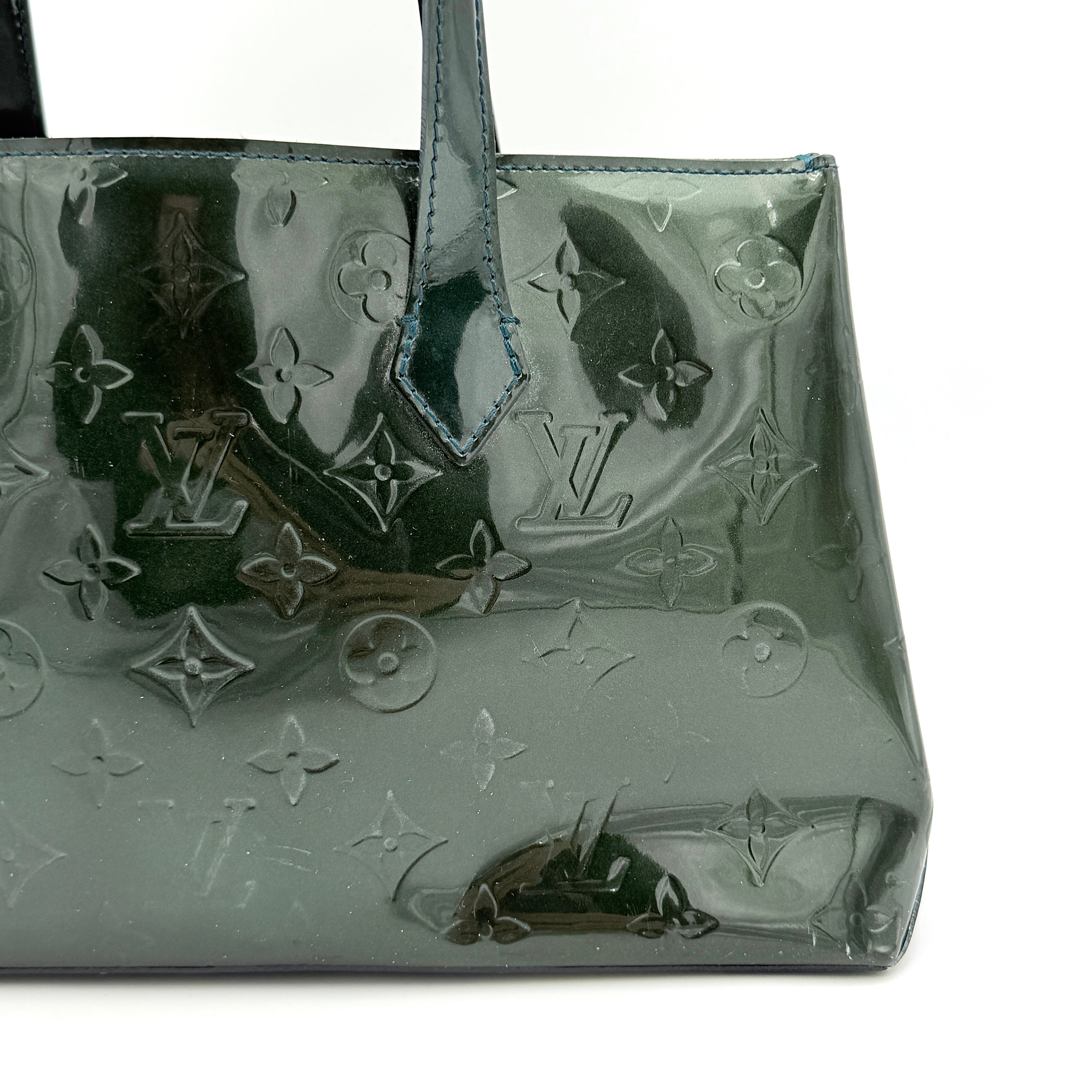 Louis Vuitton Wilshire PM bag in glossy dark green Monogram Vernis patent leather, shown with double top handles and gold-tone nameplate.
