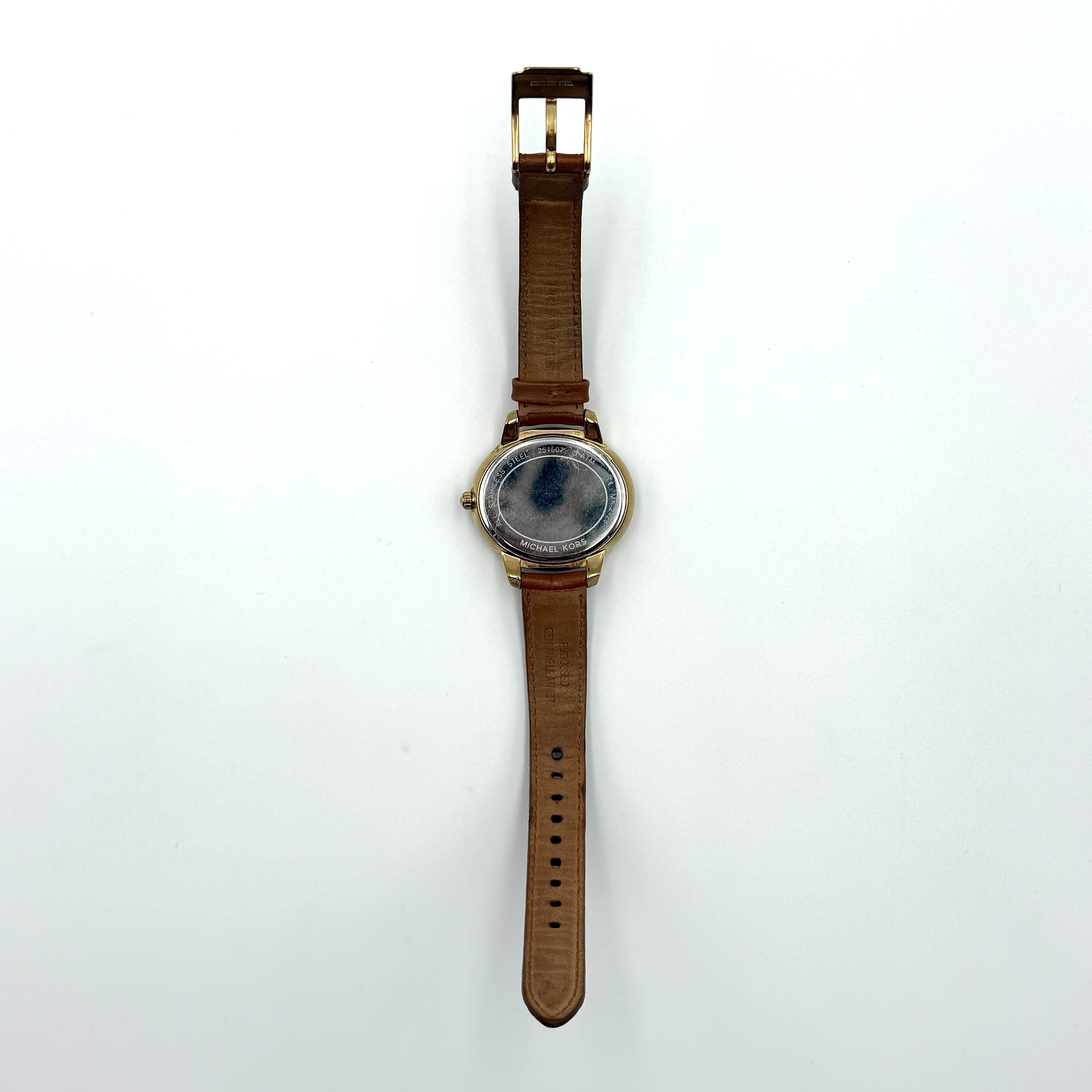 Michael Kors Whitley MK2428 watch with gold dial, crystal bezel and brown leather strap on black cushion