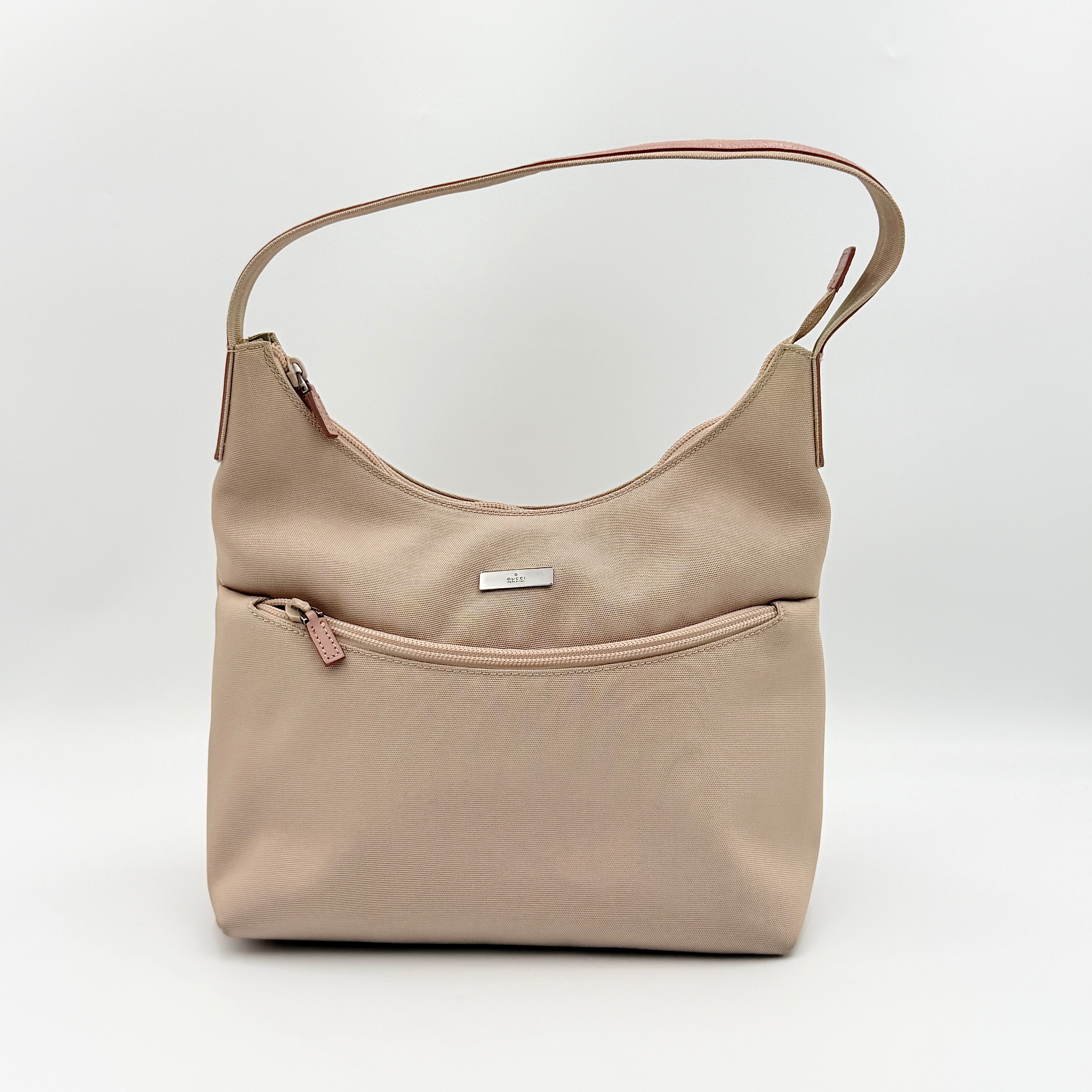 Gucci beige canvas hobo shoulder bag with pink leather accents and silver-tone hardware, displayed front-facing on a white background.