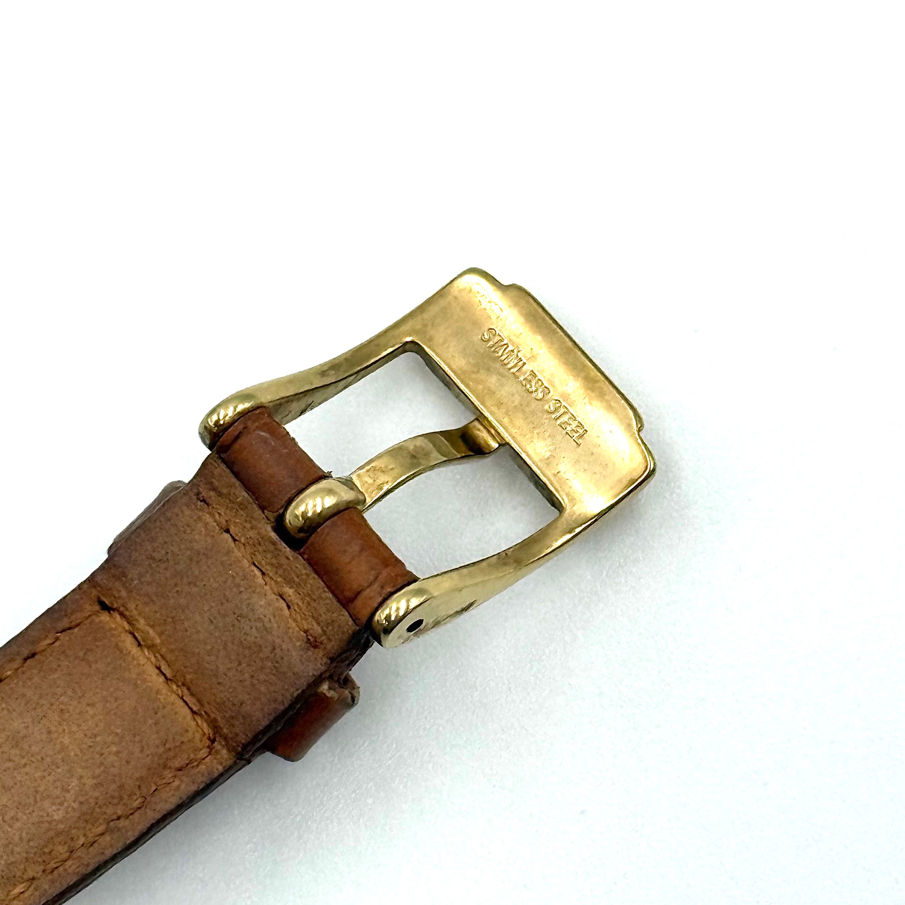 Michael Kors Whitley MK2428 watch with gold dial, crystal bezel and brown leather strap on black cushion