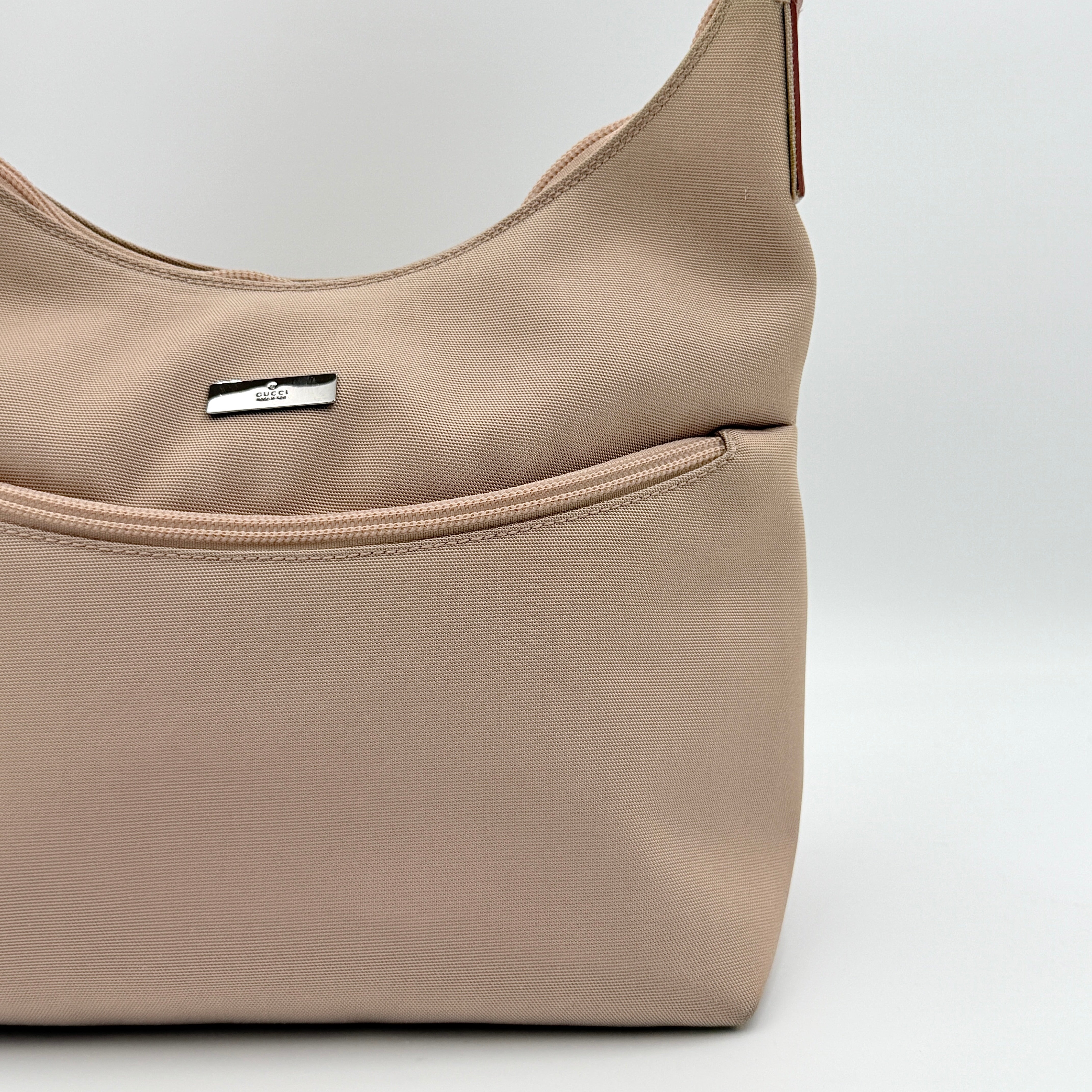 Gucci beige canvas hobo shoulder bag with pink leather accents and silver-tone hardware, displayed front-facing on a white background.