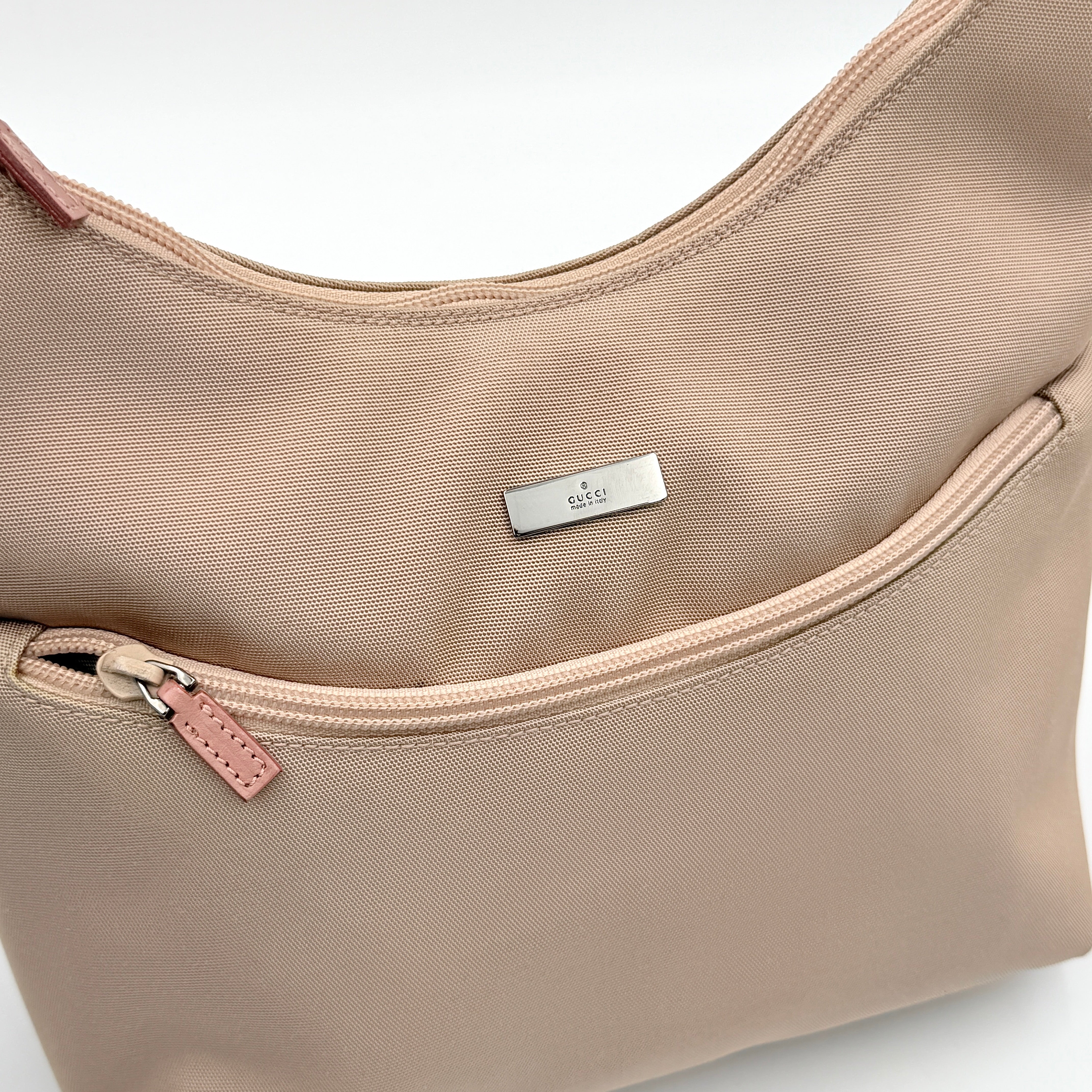 Gucci beige canvas hobo shoulder bag with pink leather accents and silver-tone hardware, displayed front-facing on a white background.