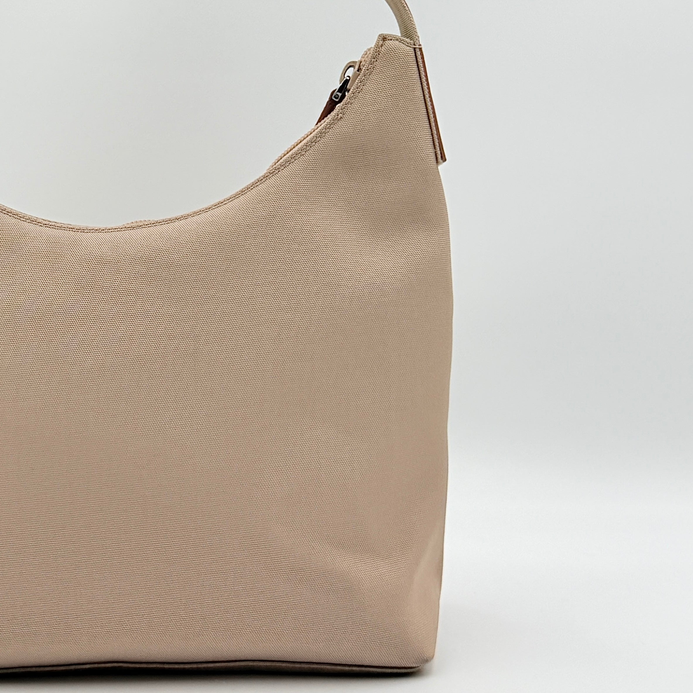 Gucci beige canvas hobo shoulder bag with pink leather accents and silver-tone hardware, displayed front-facing on a white background.