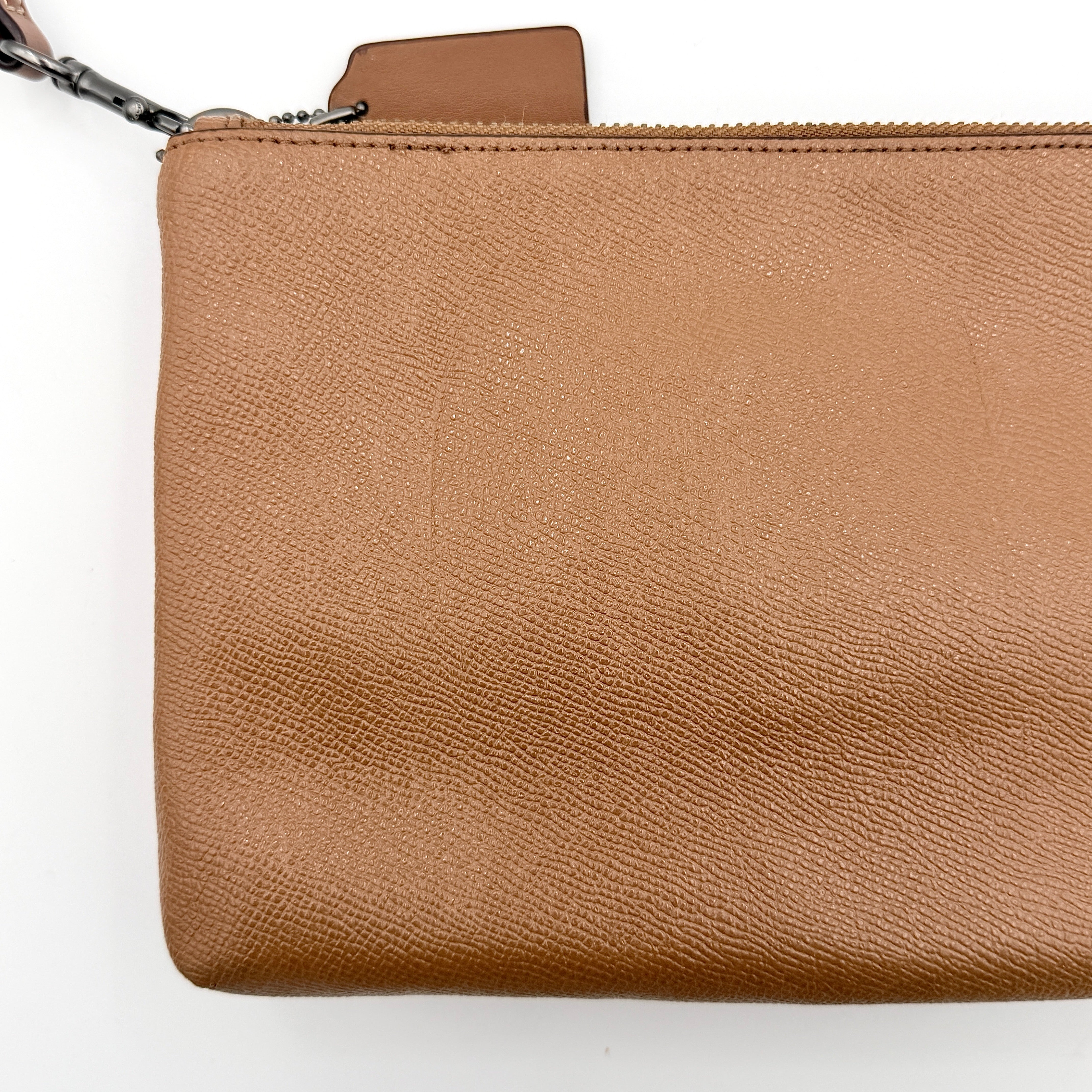 Coach x Keith Haring Lyla Crossbody bag in textured brown leather with bold pink graphic pattern and white artwork, featuring an adjustable strap.