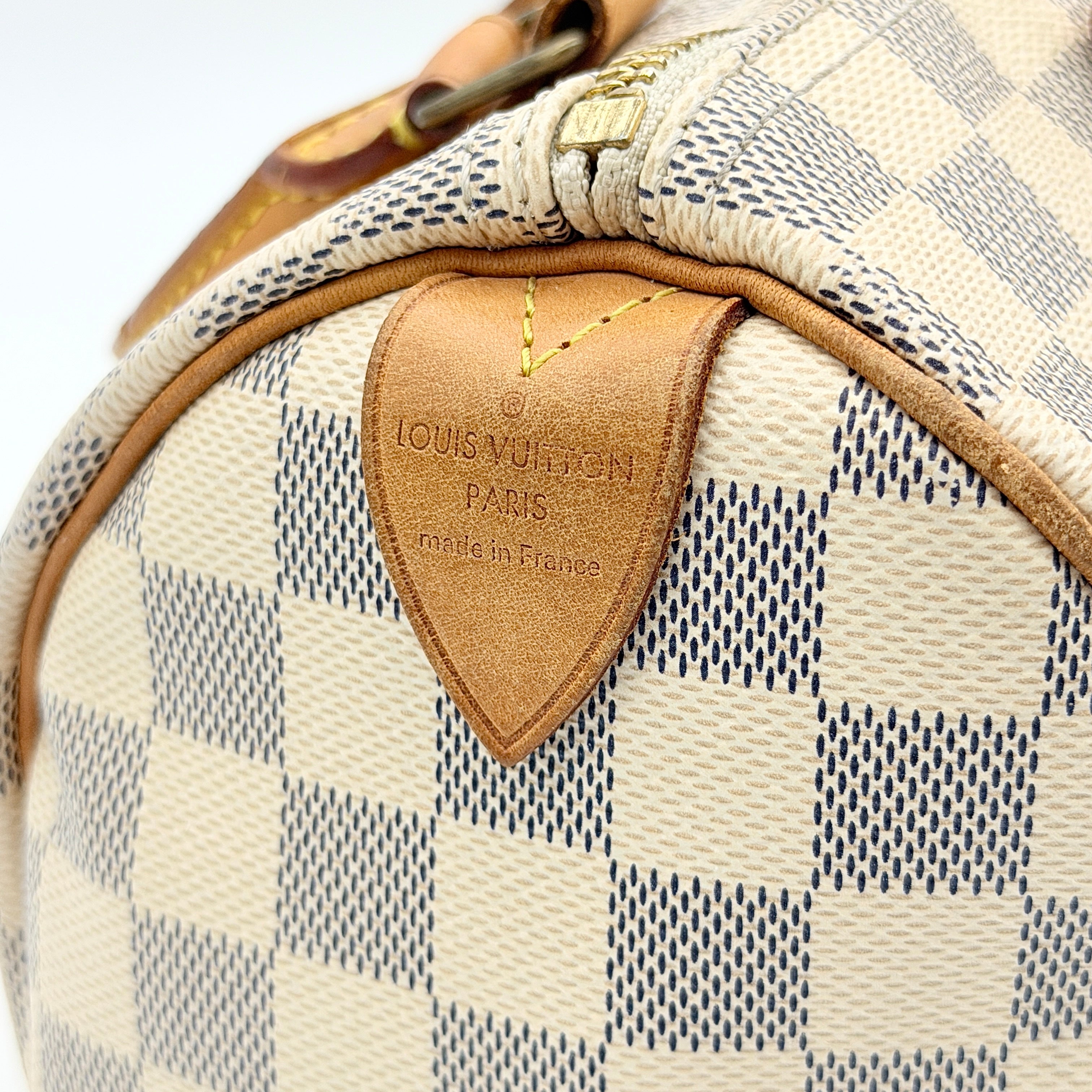 Louis Vuitton Damier Azur Speedy 25 handbag with natural leather handles, brass hardware, and included LV padlock and keys.