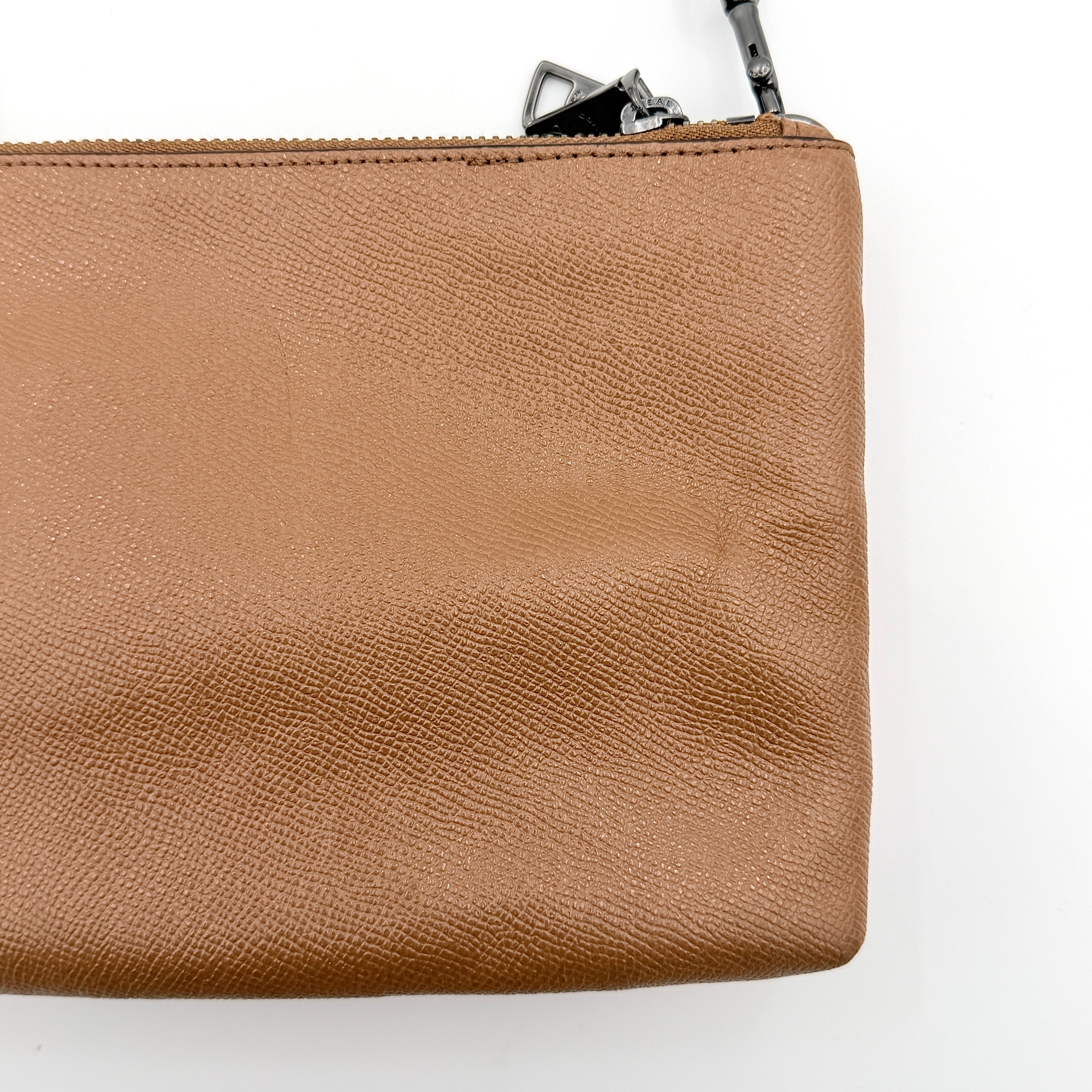 Coach x Keith Haring Lyla Crossbody bag in textured brown leather with bold pink graphic pattern and white artwork, featuring an adjustable strap.