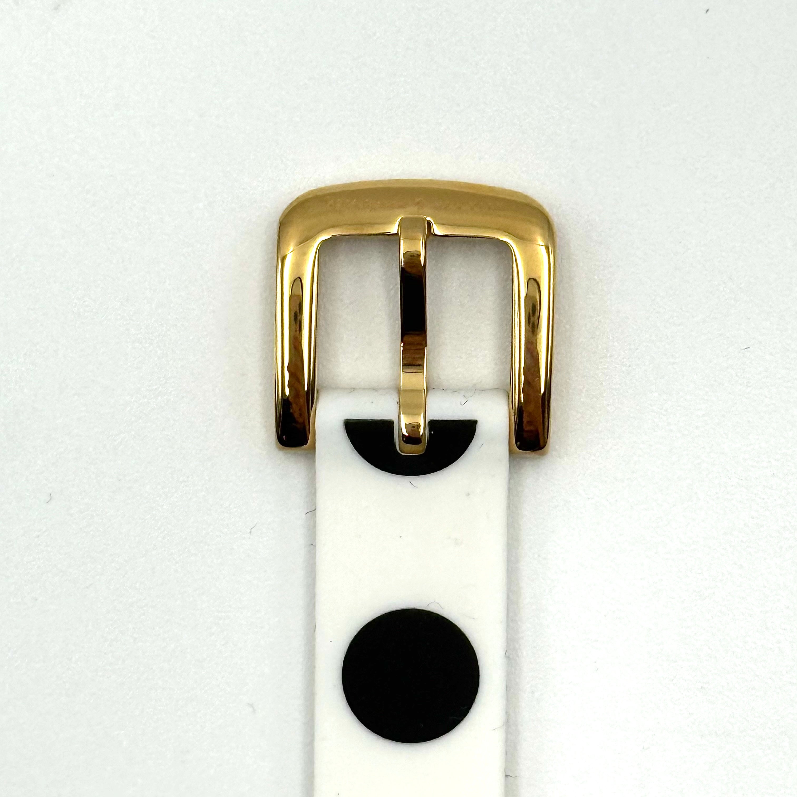 Kate Spade New York Rumsey 0838 silicone watch in white with black polka dots, gold-tone bezel, and white dial displayed on a cushion.