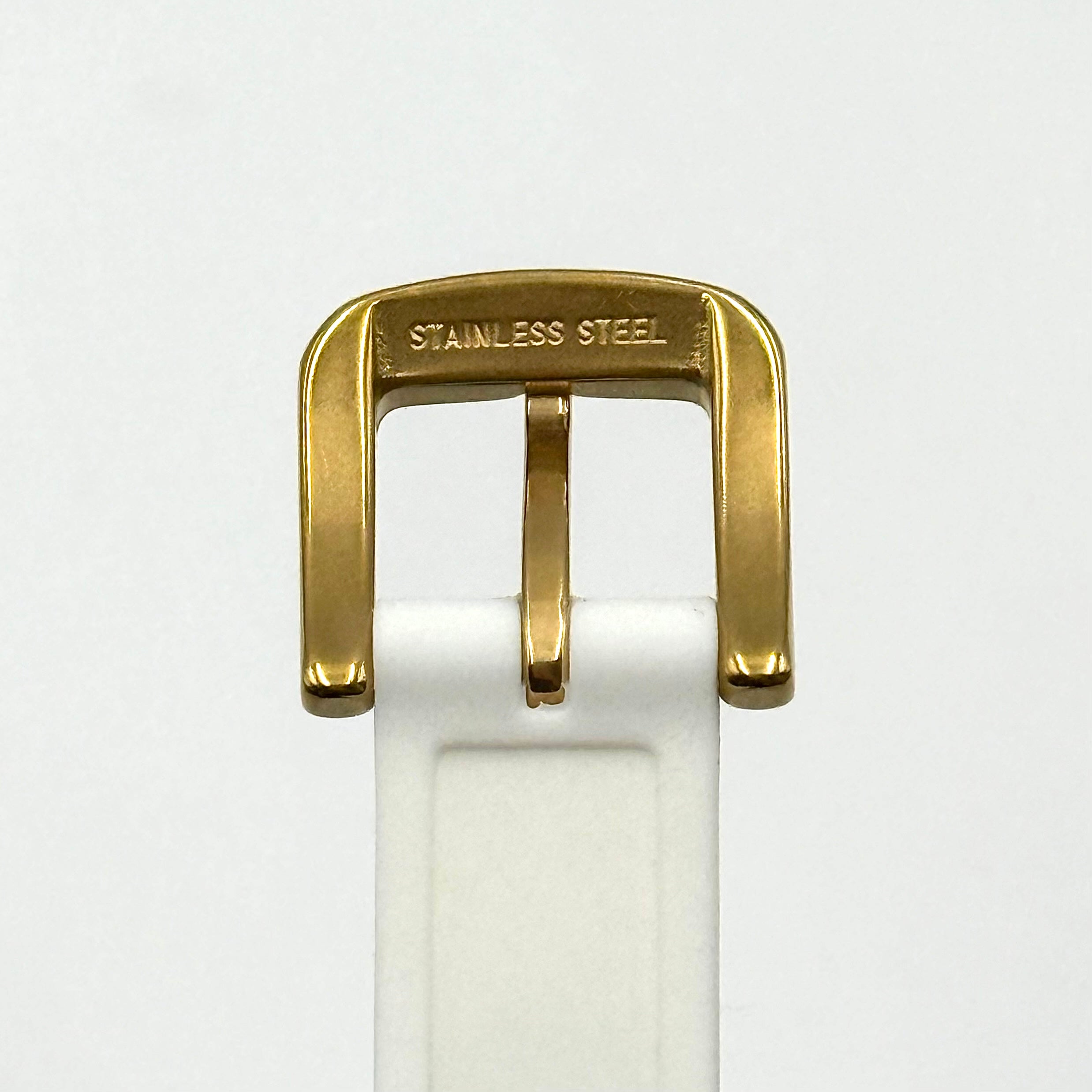 Kate Spade New York Rumsey 0838 silicone watch in white with black polka dots, gold-tone bezel, and white dial displayed on a cushion.