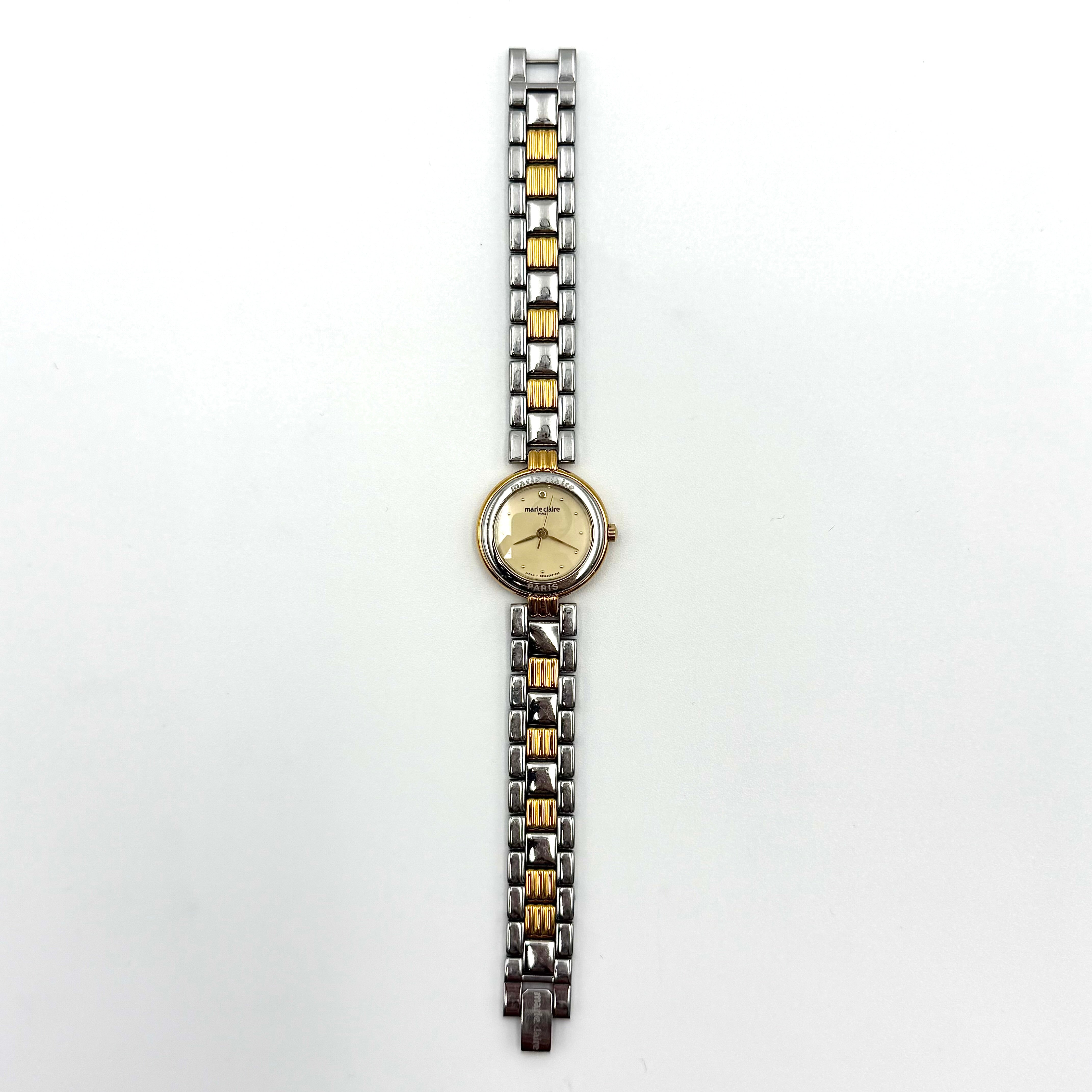 Marie Claire Paris 085268-00 two-tone gold and silver watch with a champagne dial, shown on a black pillow.