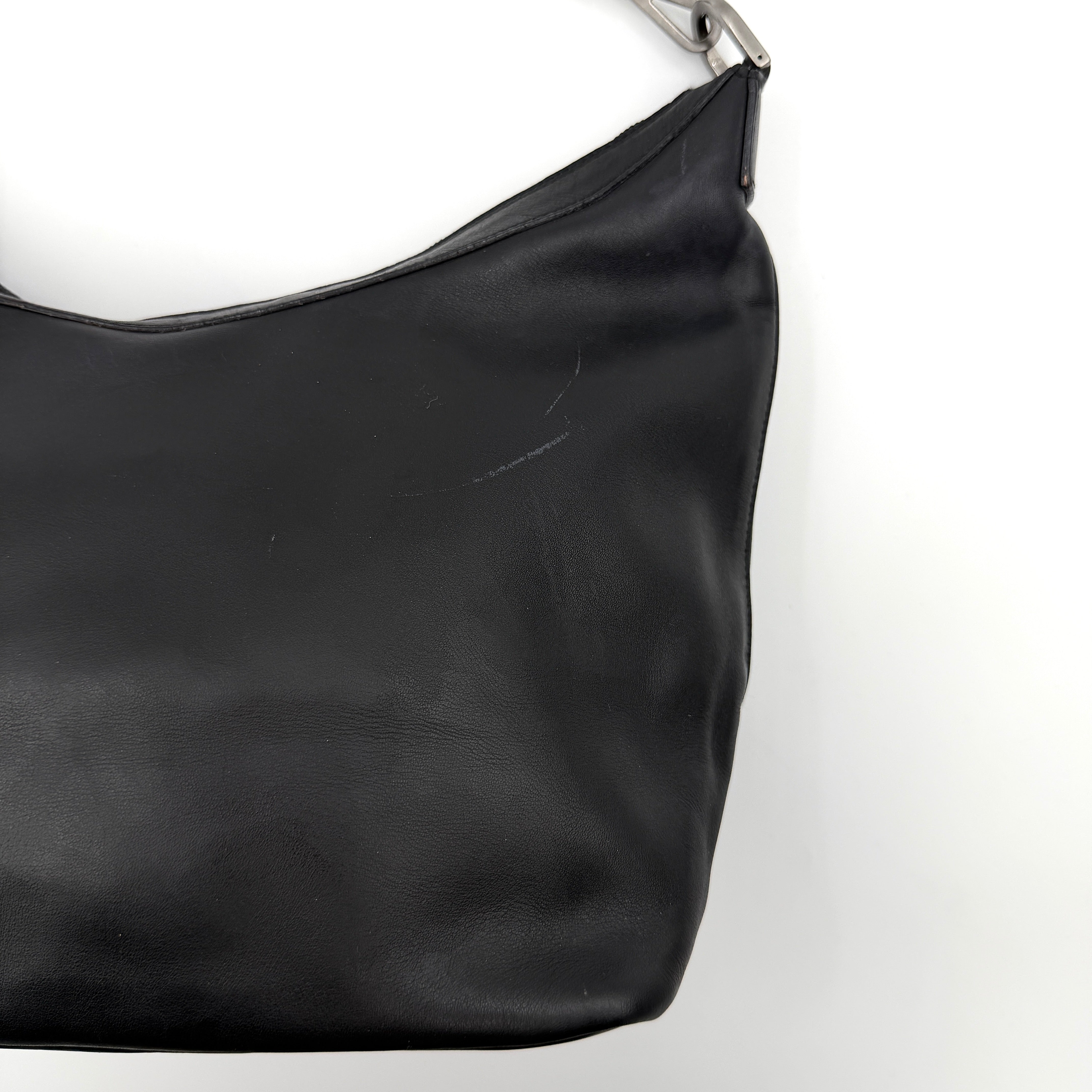 Gucci black leather hobo bag with bamboo handle and silver-tone hardware shown against a white background.