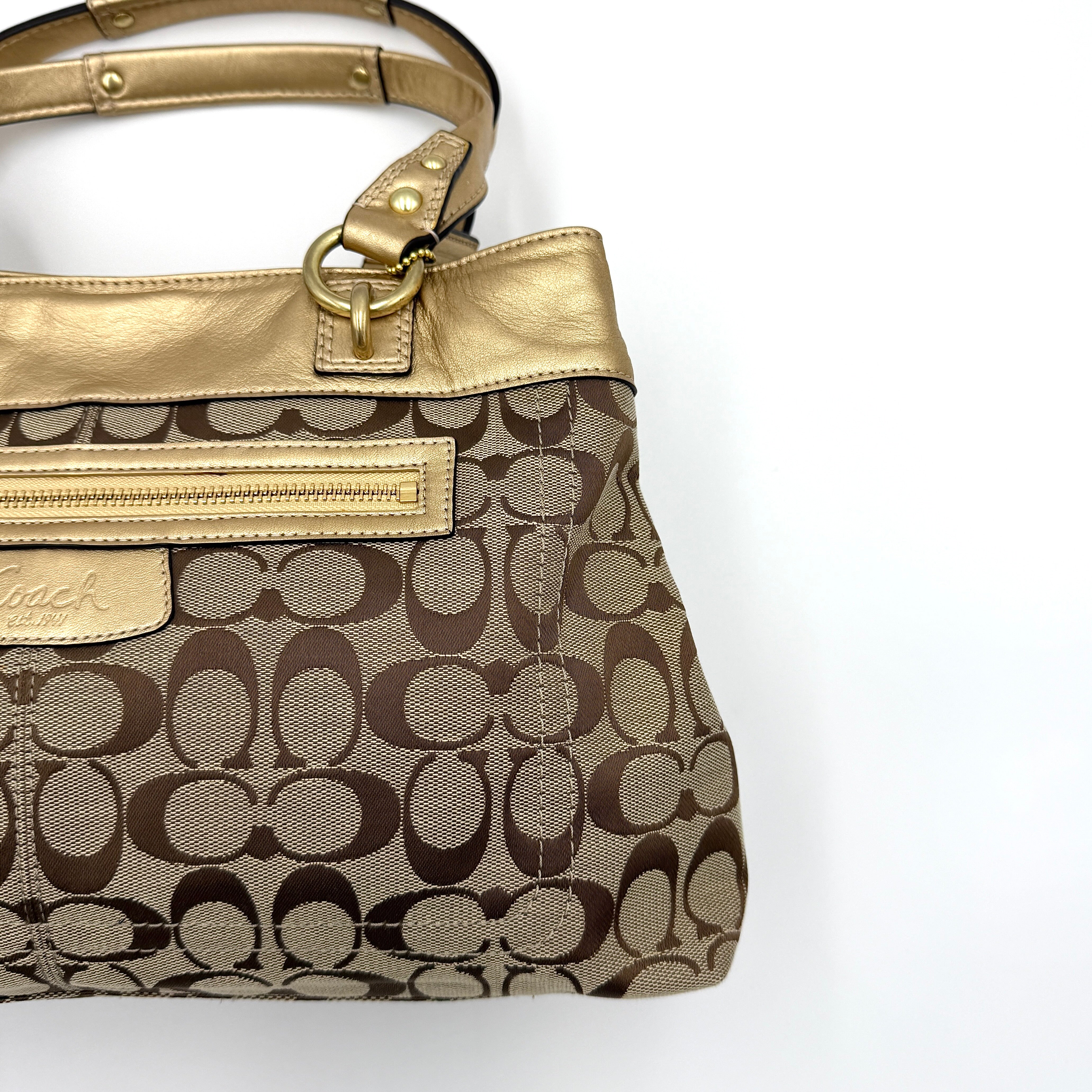 Coach Signature Penelope Shoulder Bag in beige monogram canvas with gold leather trim and gold-tone hardware displayed upright.