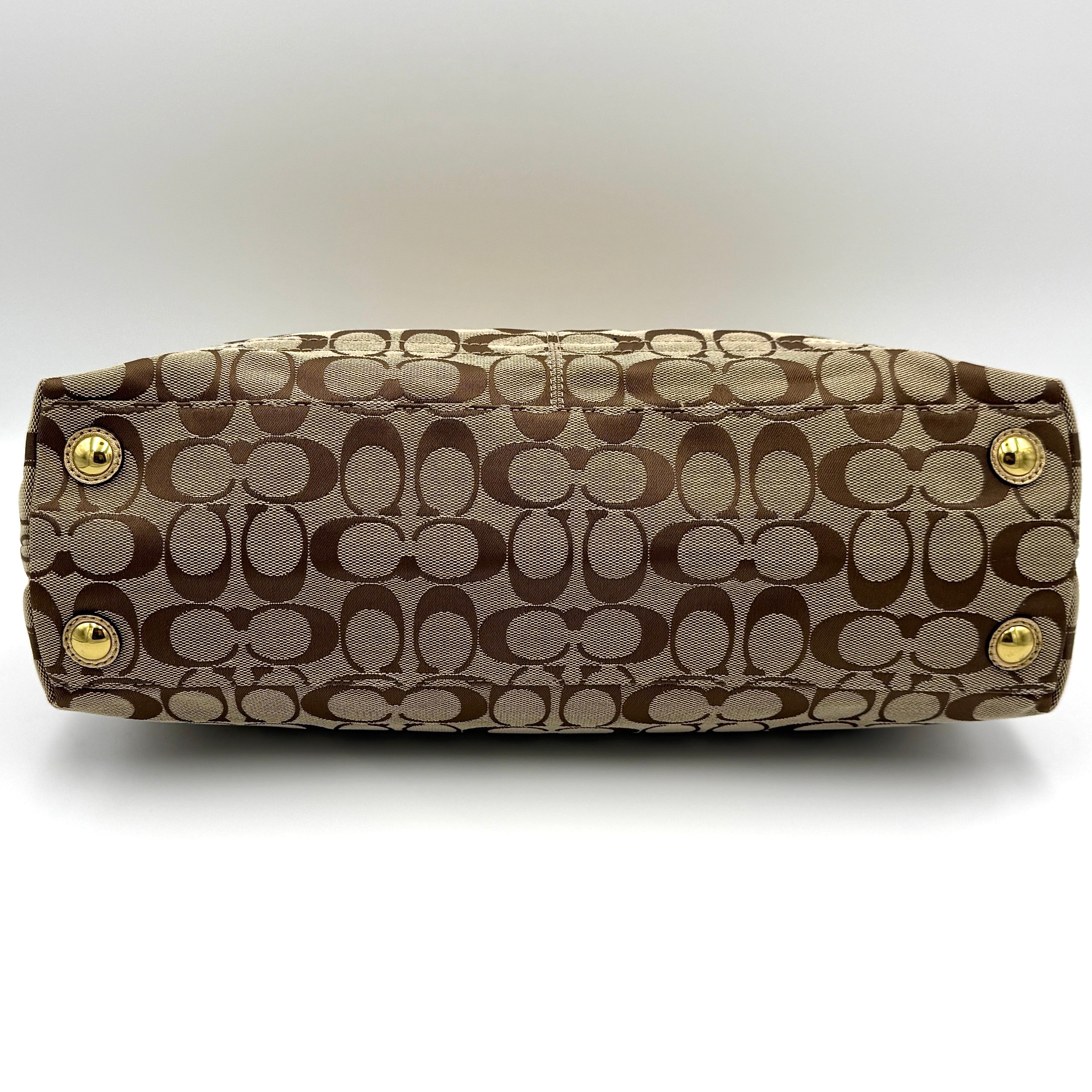 Coach Signature Penelope Shoulder Bag in beige monogram canvas with gold leather trim and gold-tone hardware displayed upright.