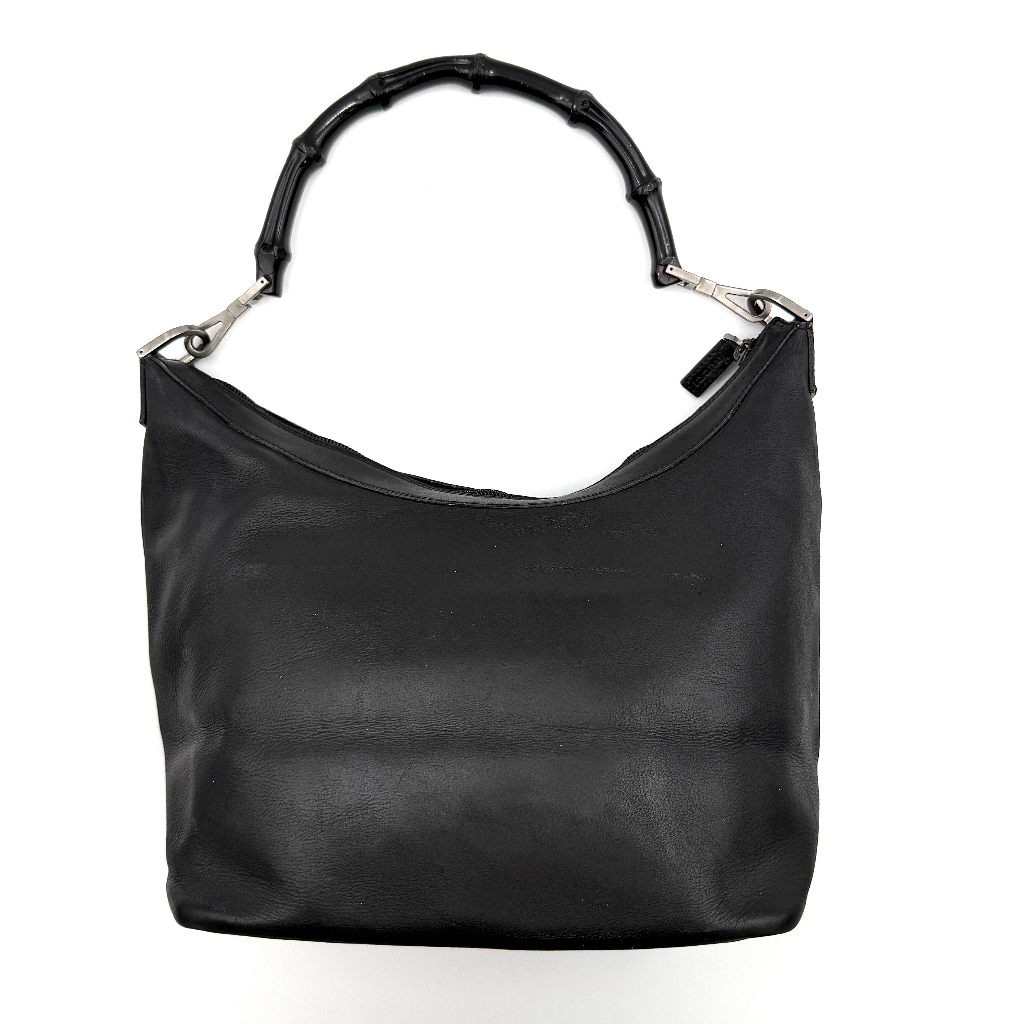 Gucci black leather hobo bag with bamboo handle and silver-tone hardware shown against a white background.