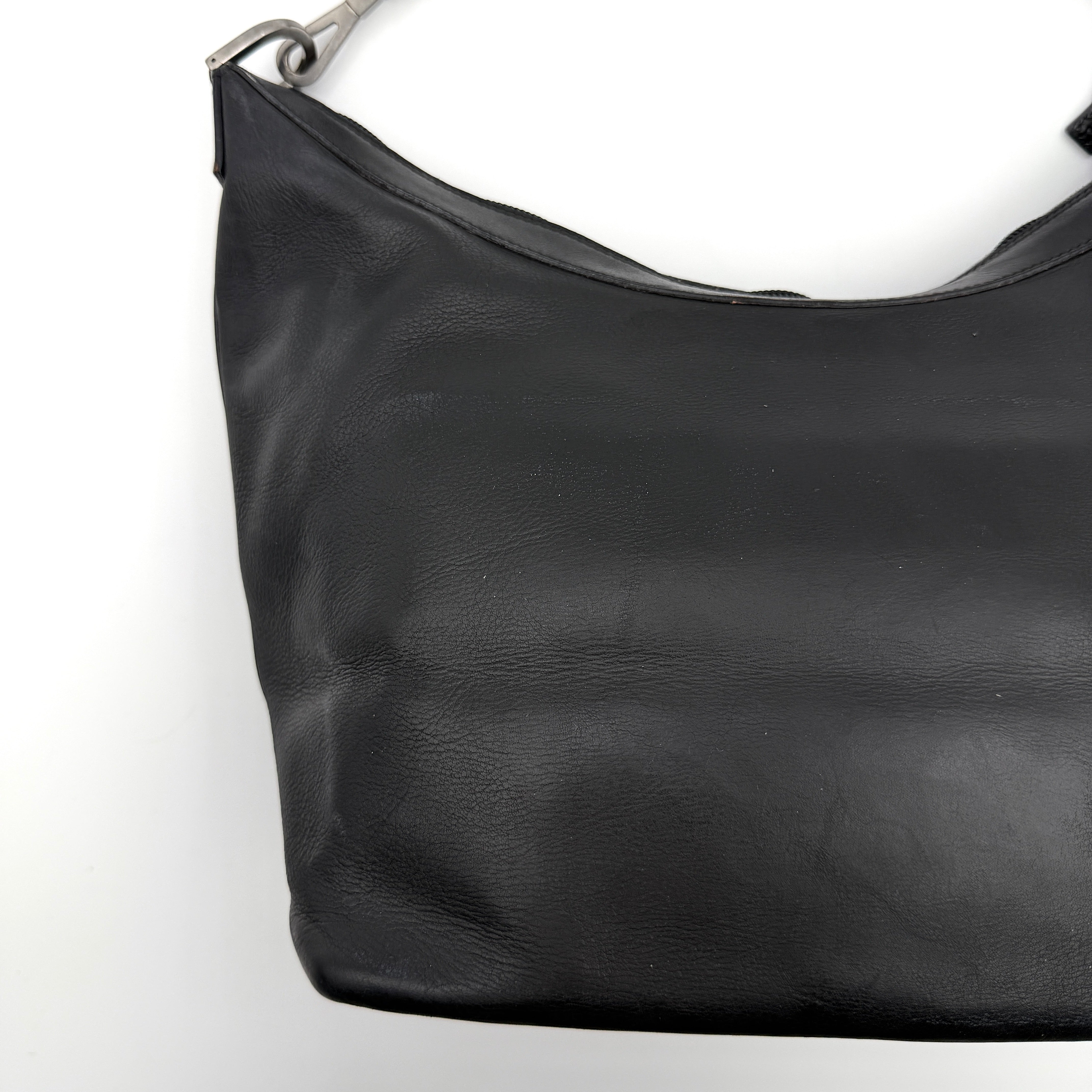 Gucci black leather hobo bag with bamboo handle and silver-tone hardware shown against a white background.
