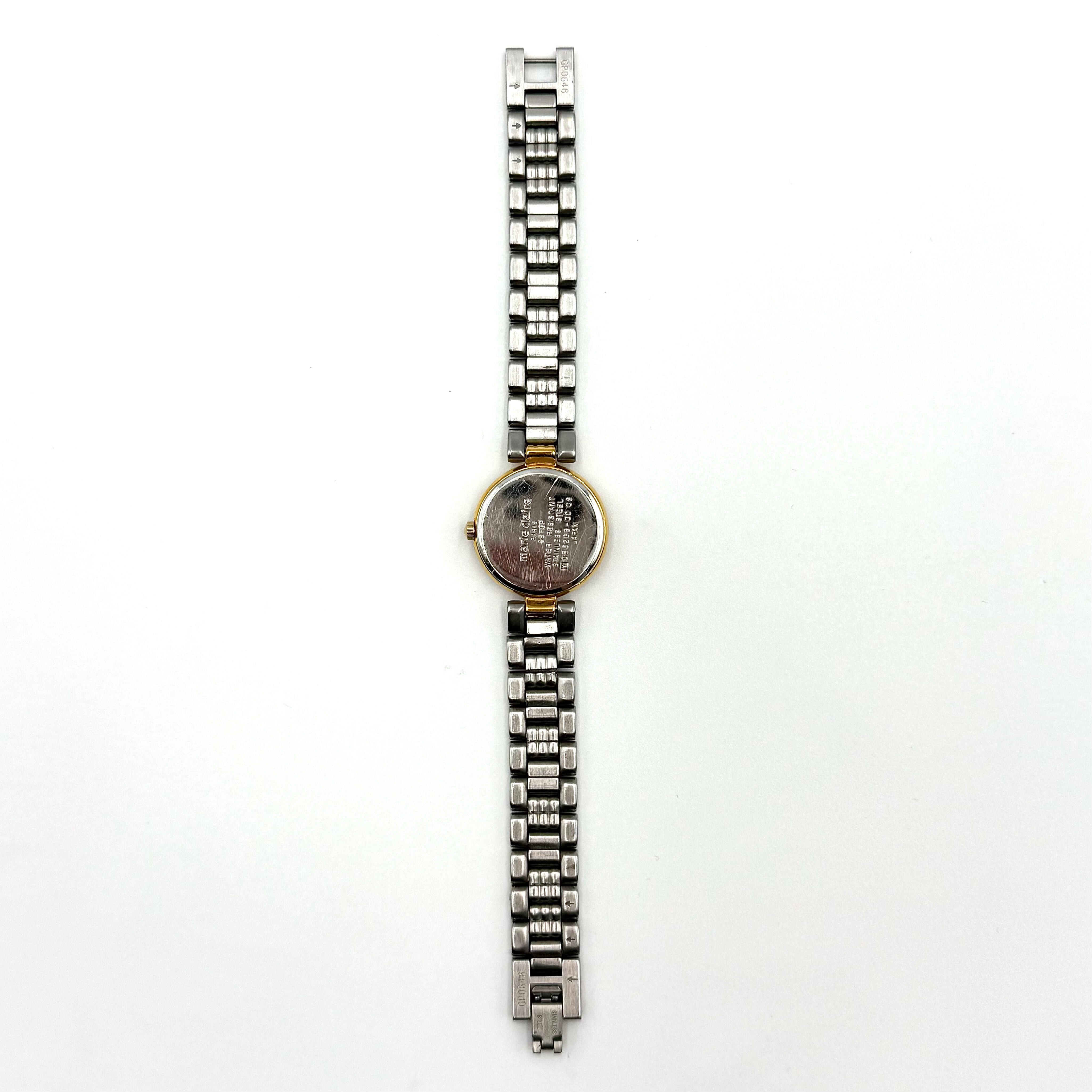 Marie Claire Paris 085268-00 two-tone gold and silver watch with a champagne dial, shown on a black pillow.