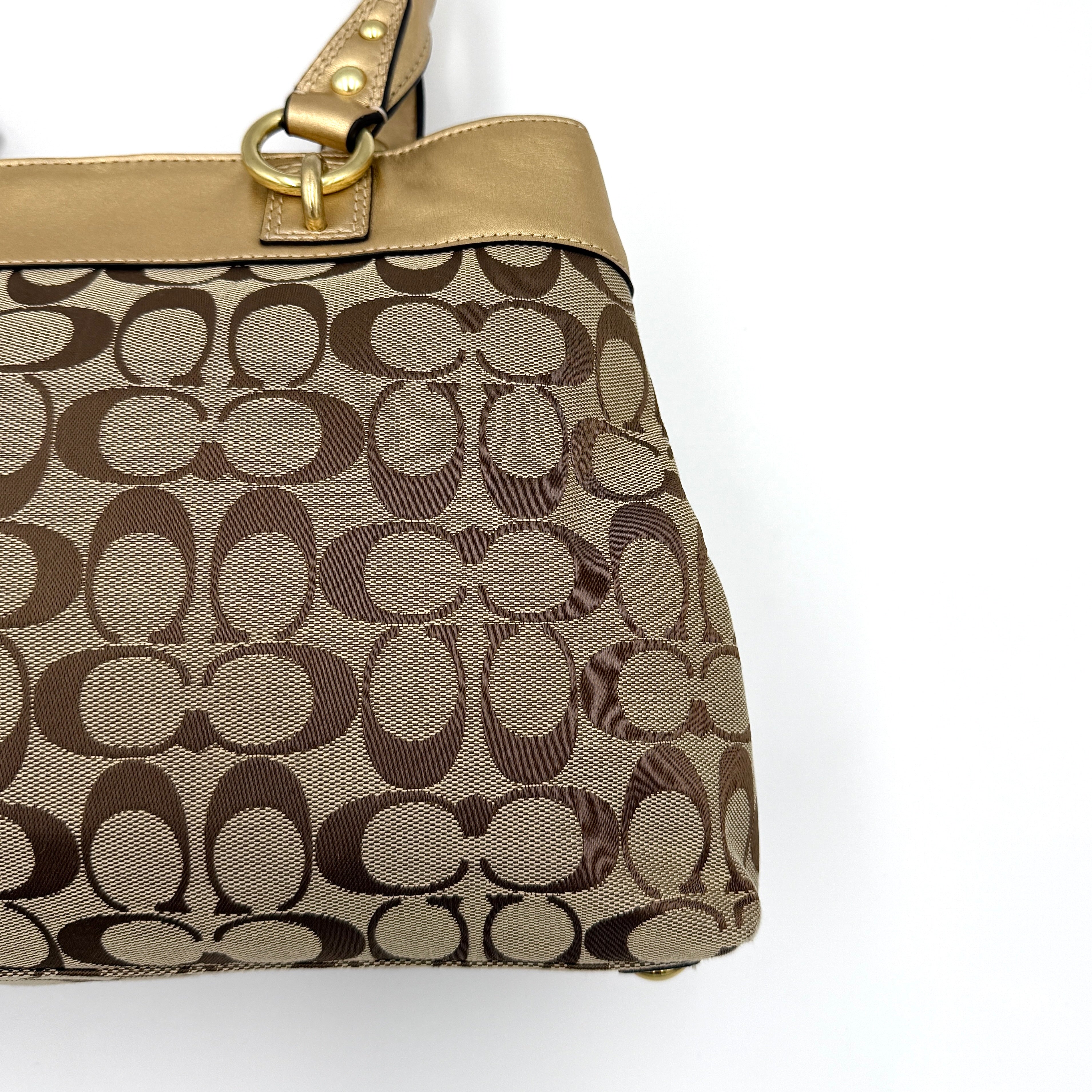 Coach Signature Penelope Shoulder Bag in beige monogram canvas with gold leather trim and gold-tone hardware displayed upright.