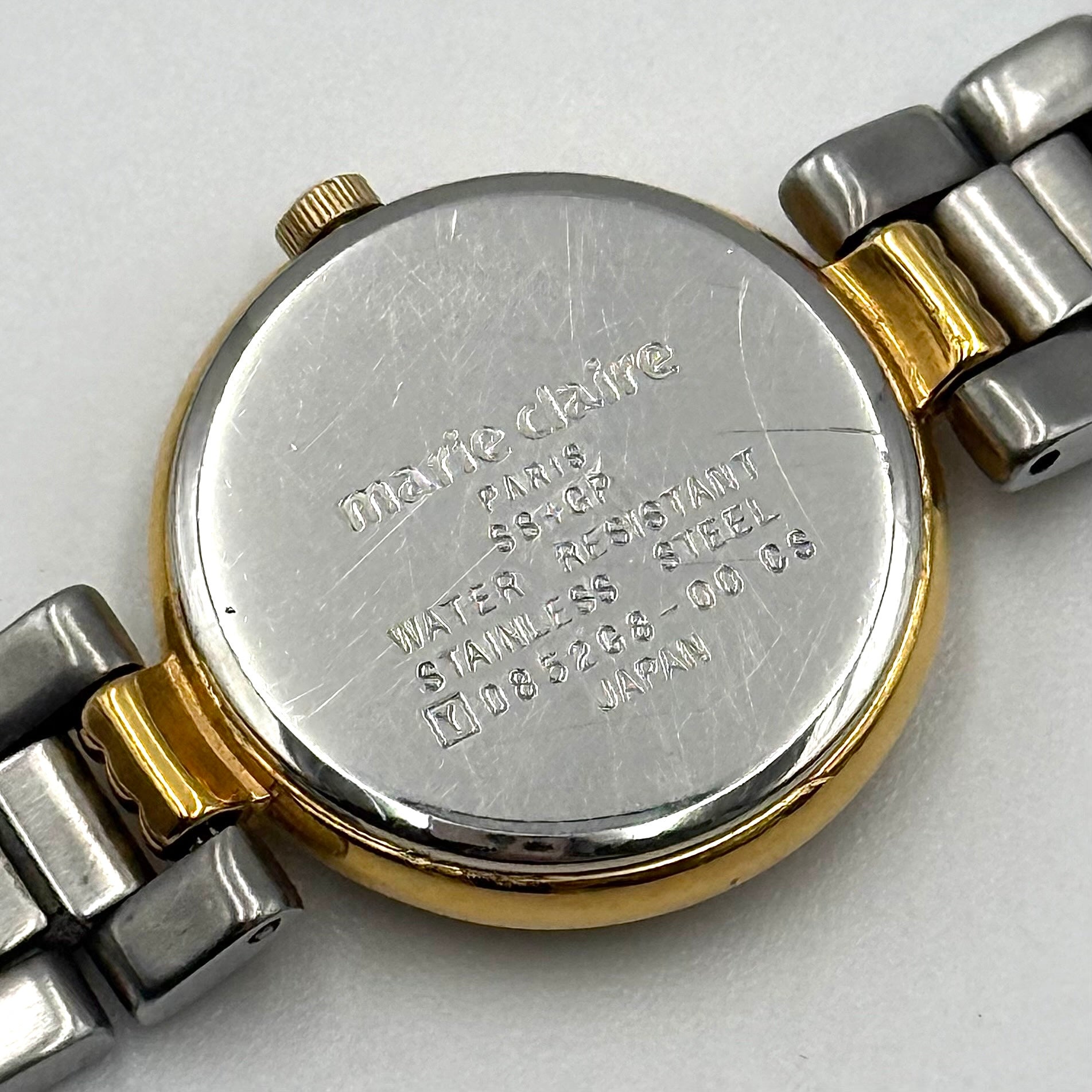 Marie Claire Paris 085268-00 two-tone gold and silver watch with a champagne dial, shown on a black pillow.