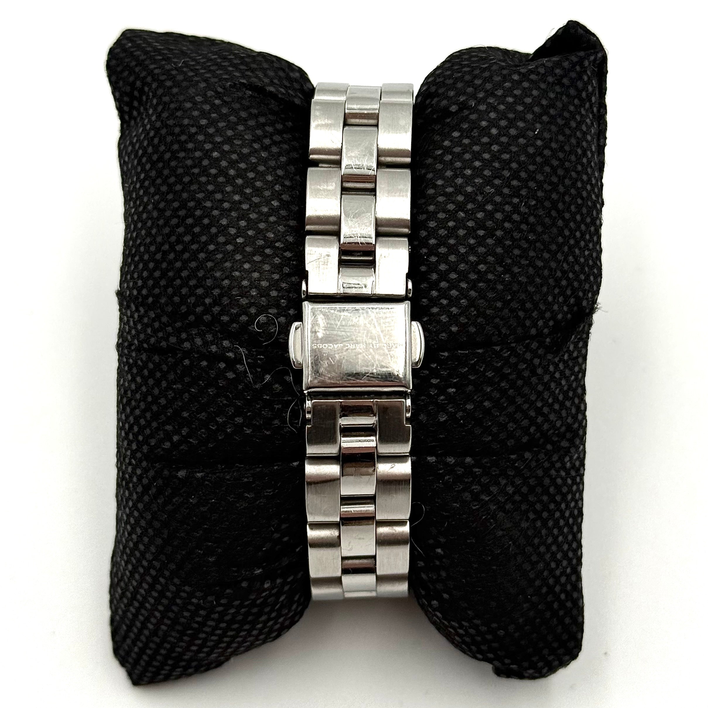 Marc Jacobs Blade MBM3049 watch in stainless steel with a cream bezel, shown on a black cushion.