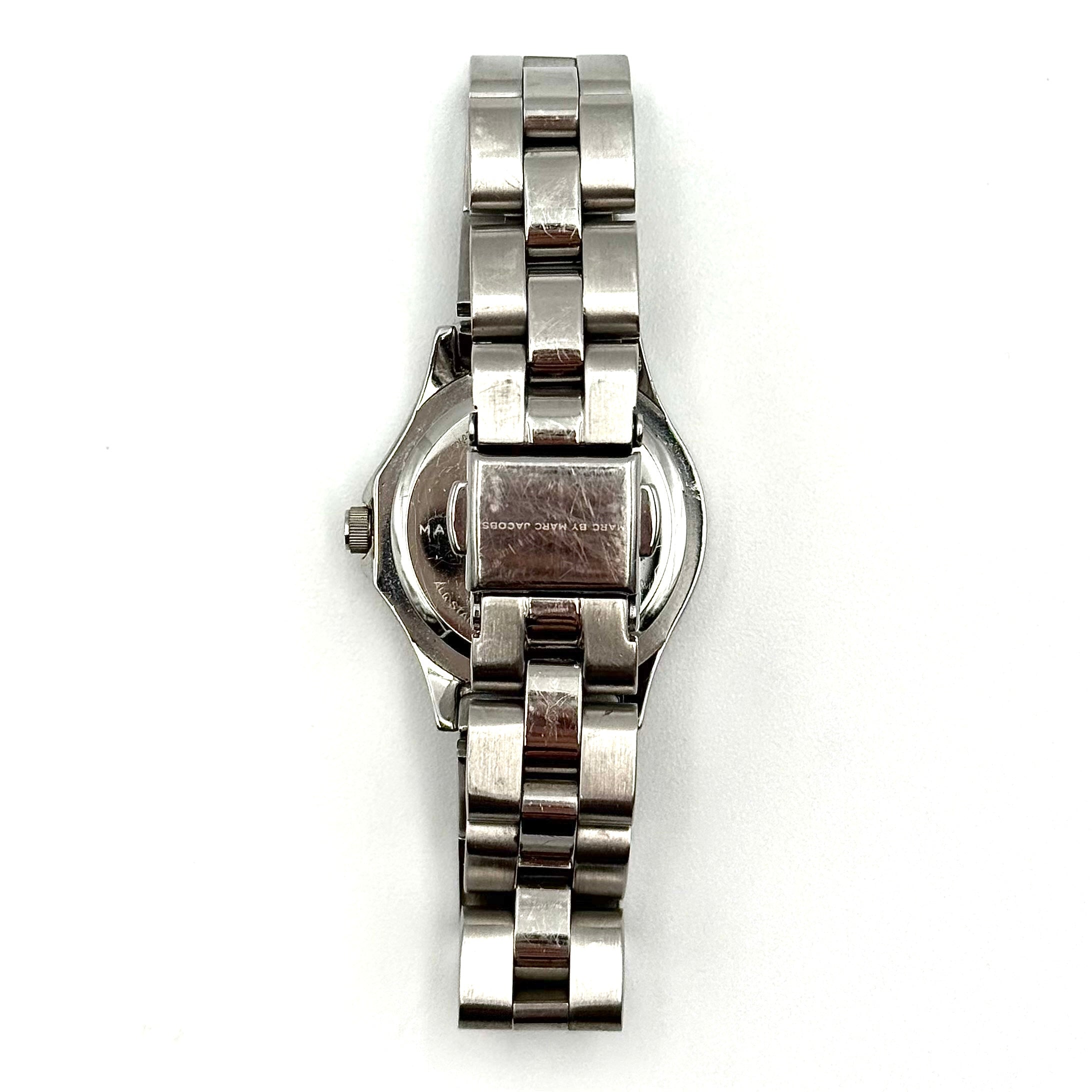 Marc Jacobs Blade MBM3049 watch in stainless steel with a cream bezel, shown on a black cushion.