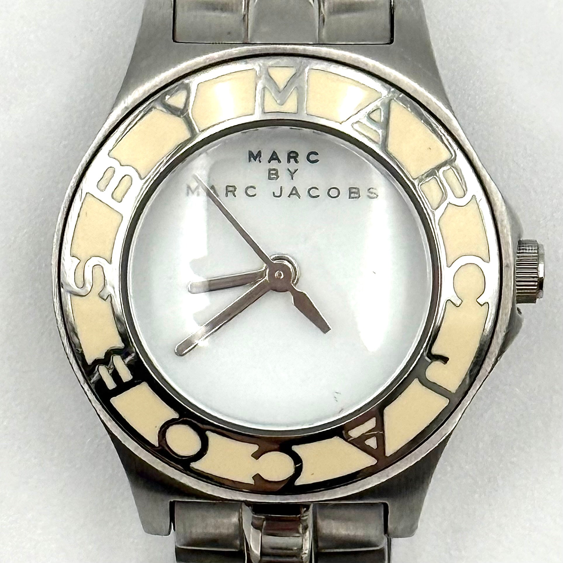 Marc Jacobs Blade MBM3049 watch in stainless steel with a cream bezel, shown on a black cushion.