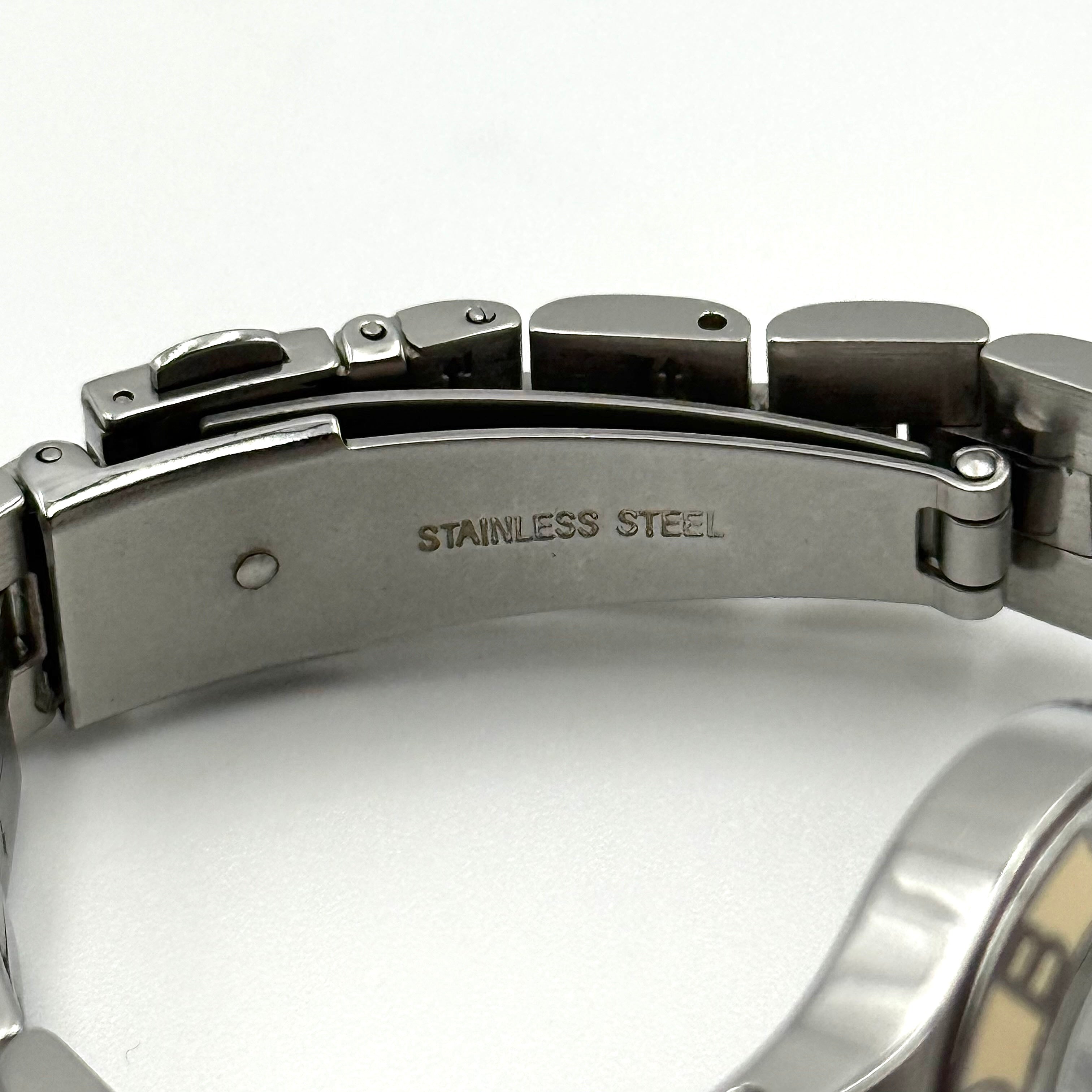 Marc Jacobs Blade MBM3049 watch in stainless steel with a cream bezel, shown on a black cushion.