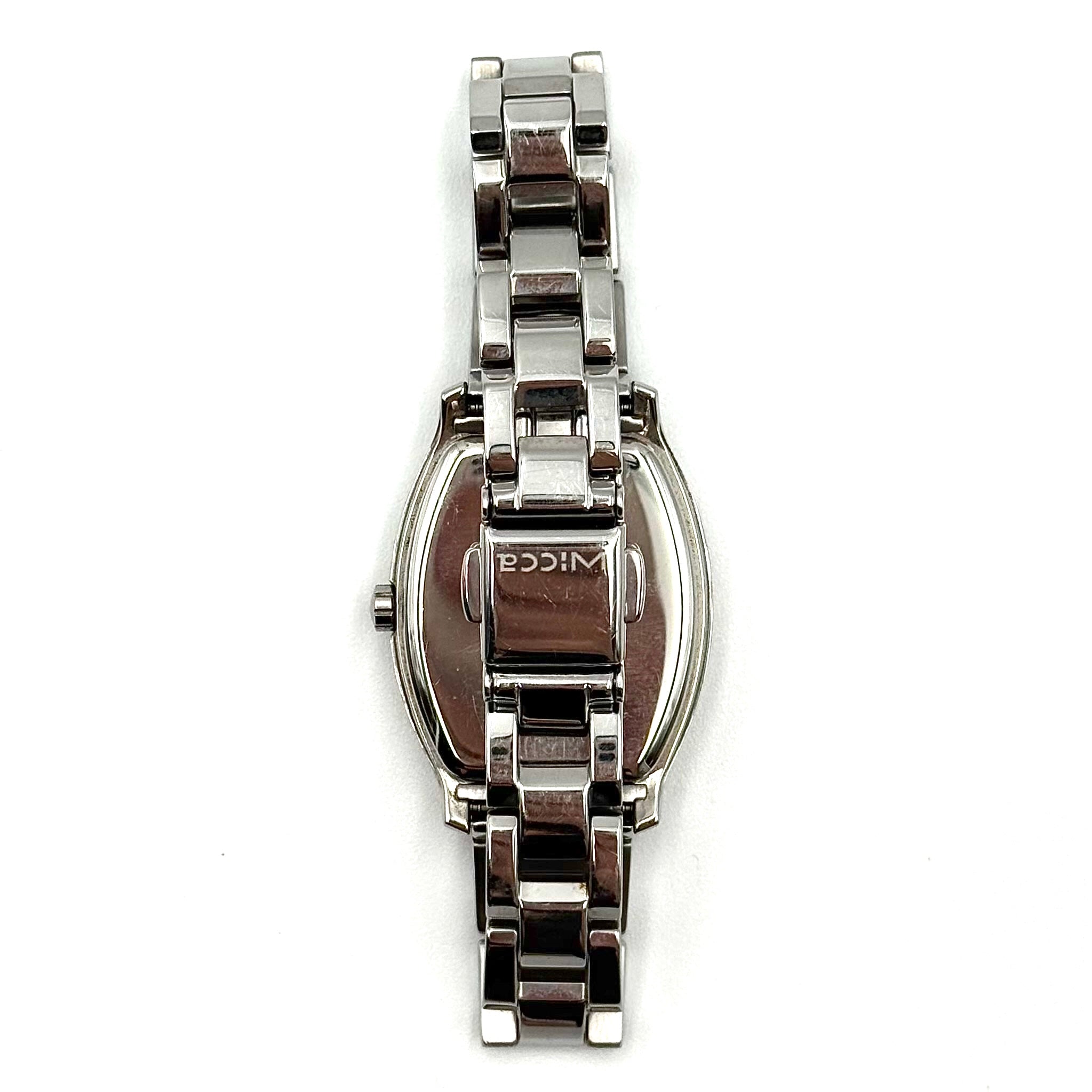 Citizen Wicca stainless steel watch with pink dial and star-detailed bezel shown on a black cushion.