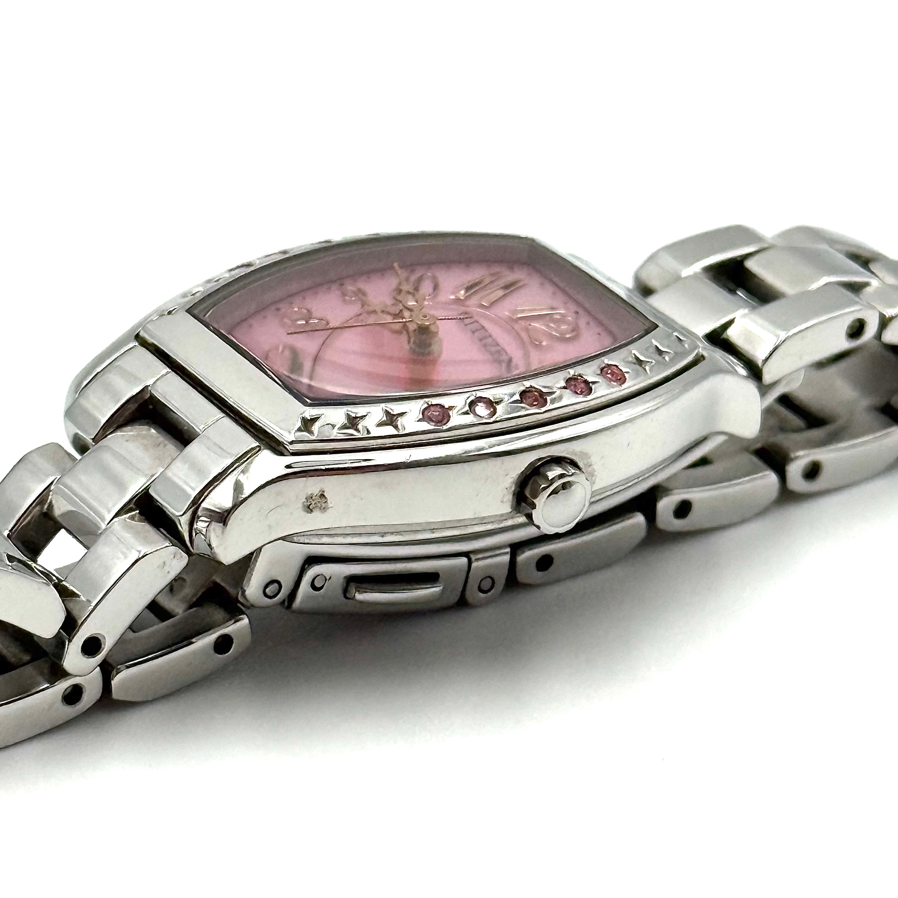 Citizen Wicca stainless steel watch with pink dial and star-detailed bezel shown on a black cushion.