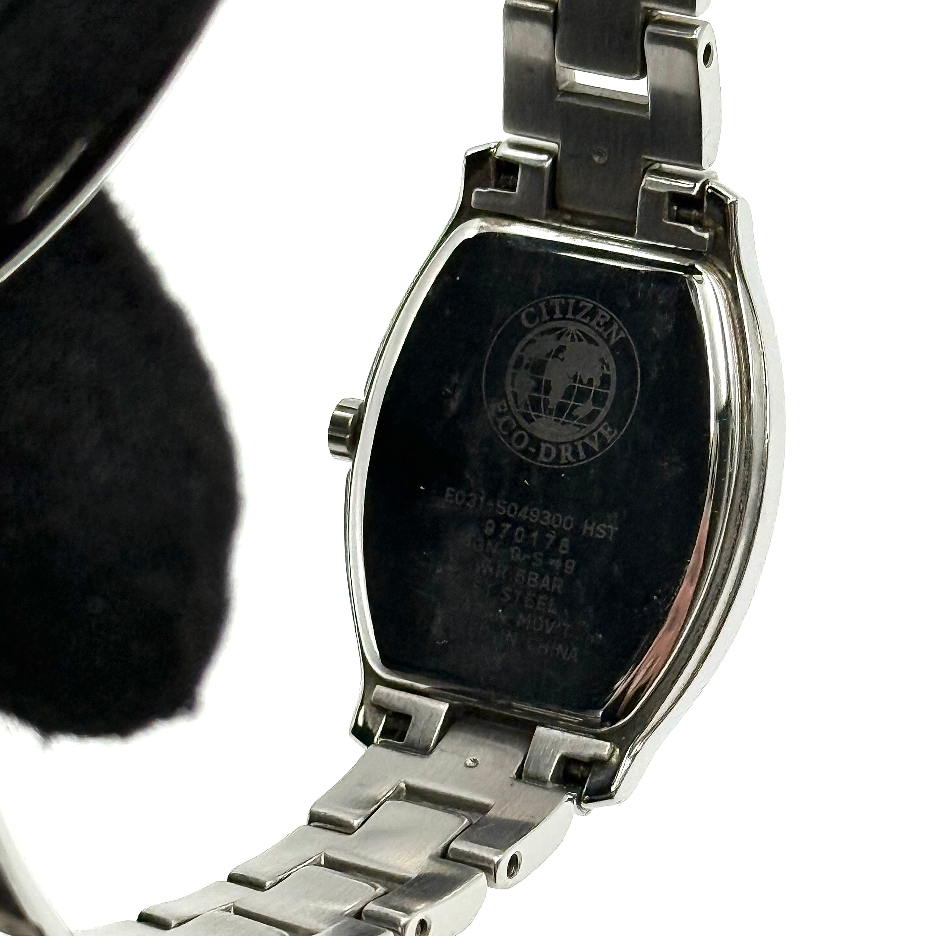 Citizen Wicca stainless steel watch with pink dial and star-detailed bezel shown on a black cushion.