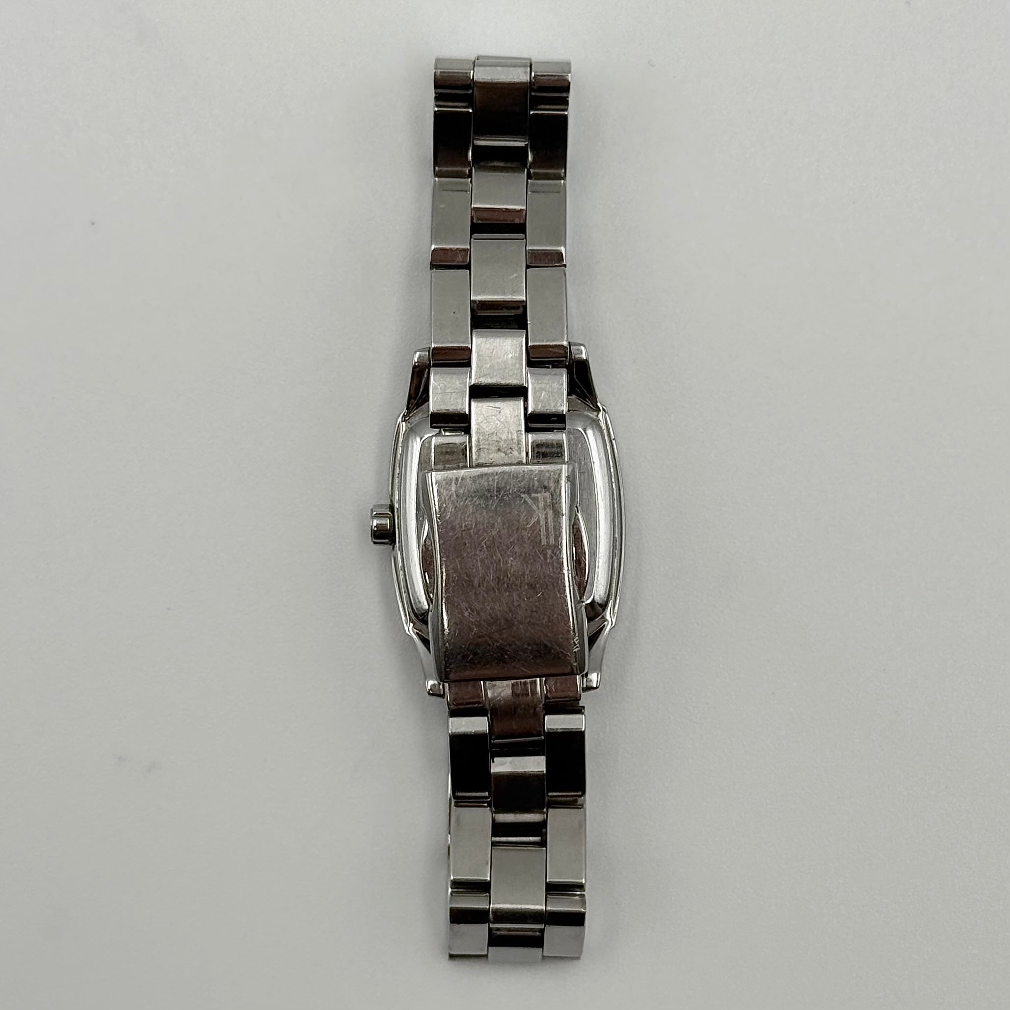 Seiko Lukia stainless steel watch with a rectangular case and silver dial presented on a cushion.