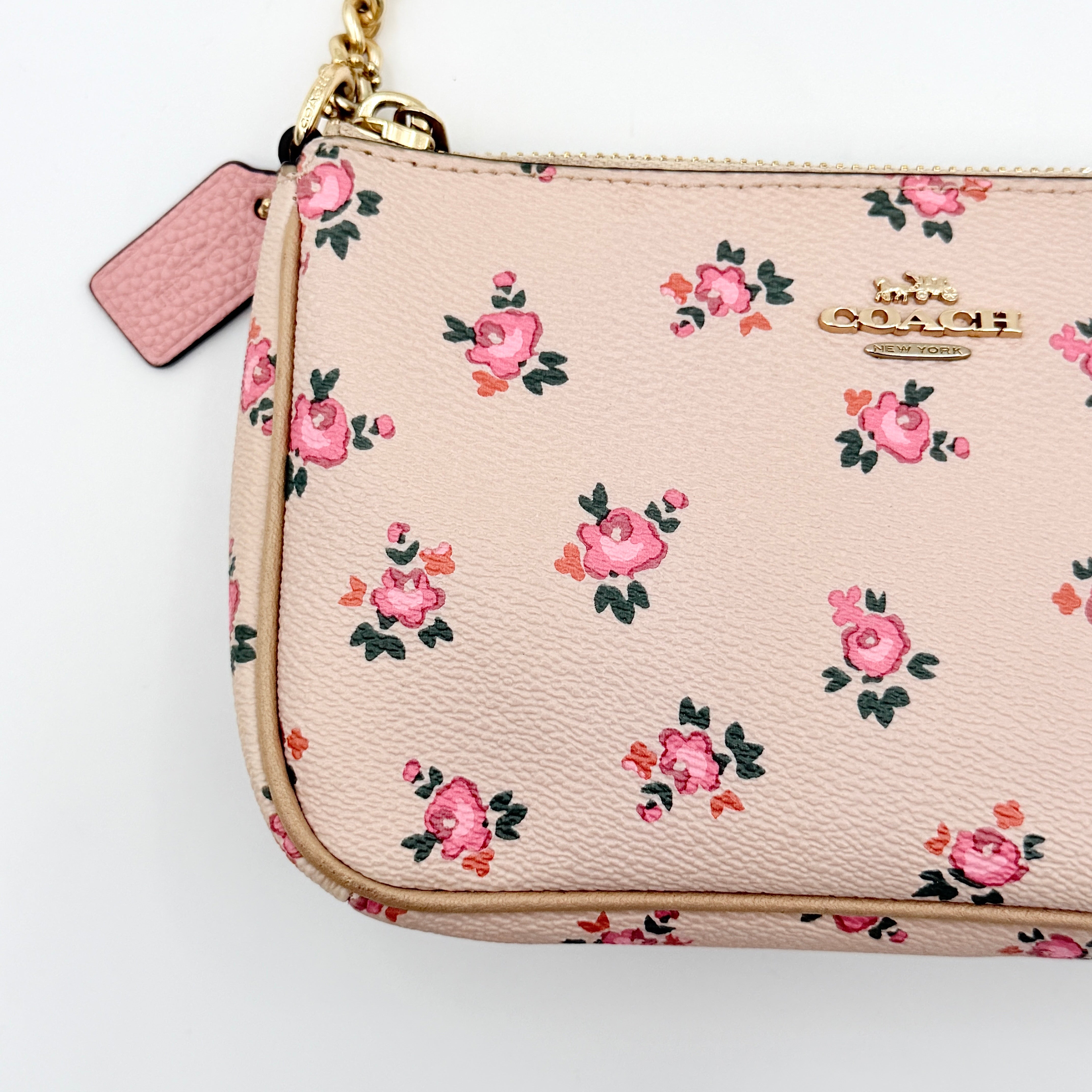 Coach Nolita 19 pink shoulder bag in floral print with gold chain handle, photographed against a white background.