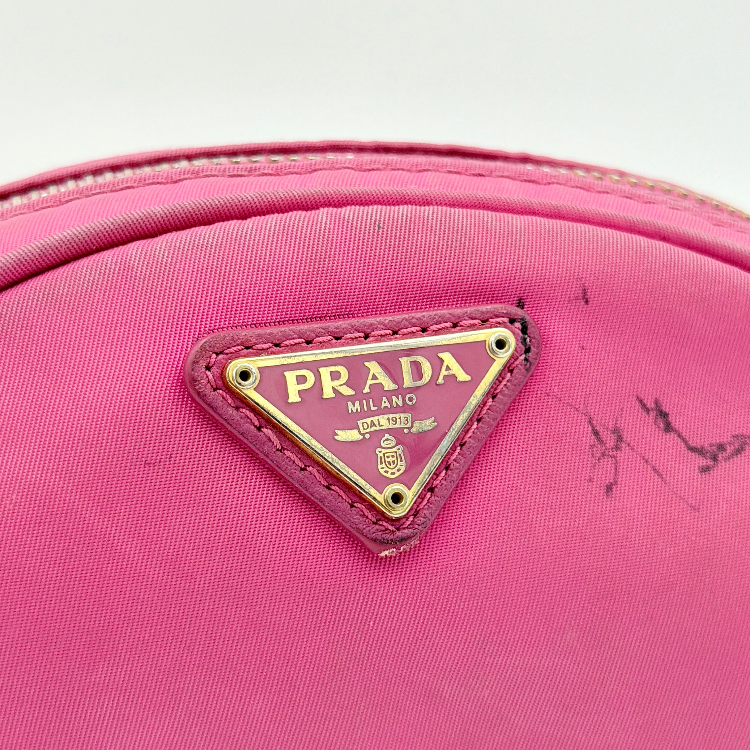 Prada Tessuto Nylon Pouch in vibrant pink with gold-tone hardware and triangle logo, showing visible wear on the exterior.