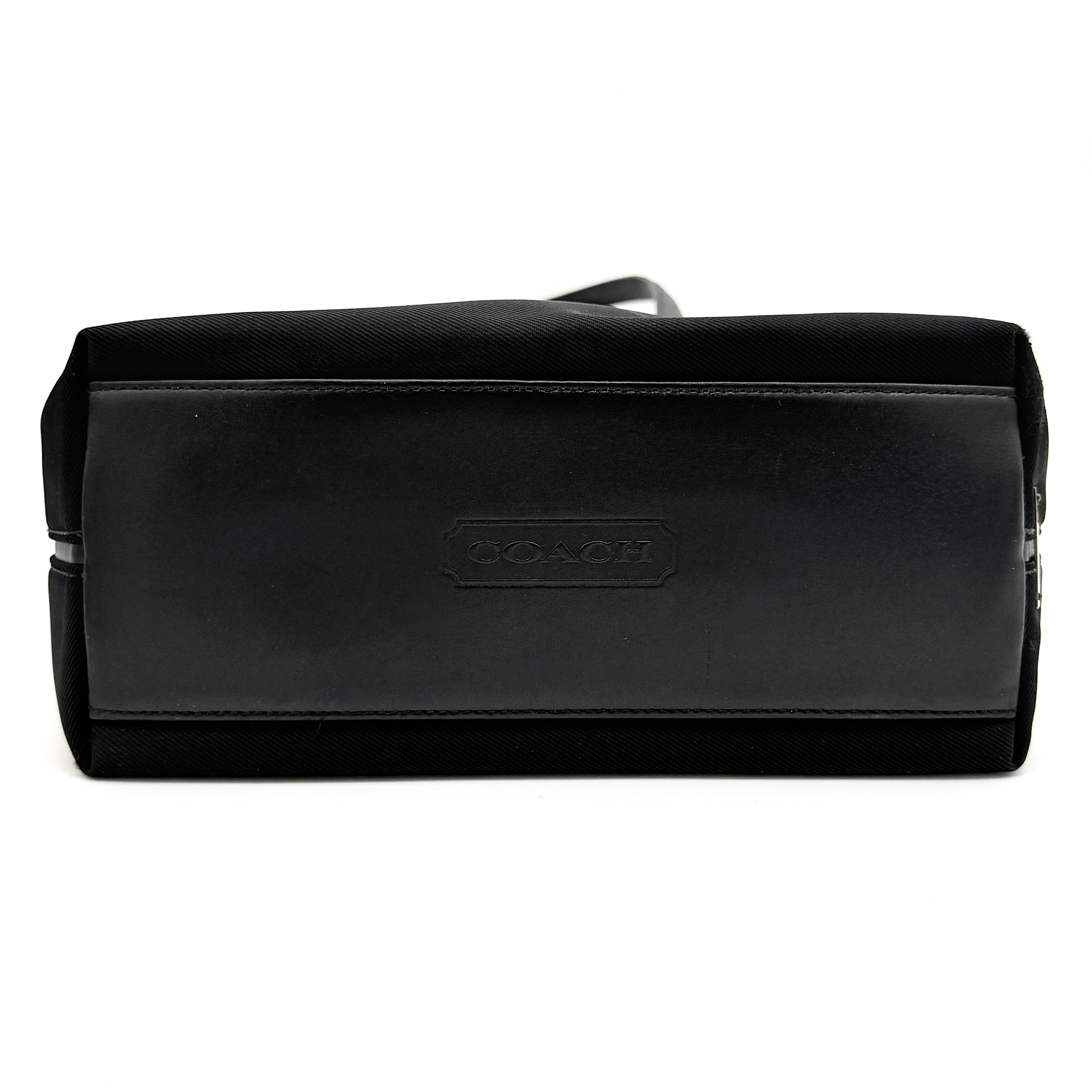 Coach Mercer Nylon Tote Bag in black with leather handles and silver Coach tag, photographed on a white background.