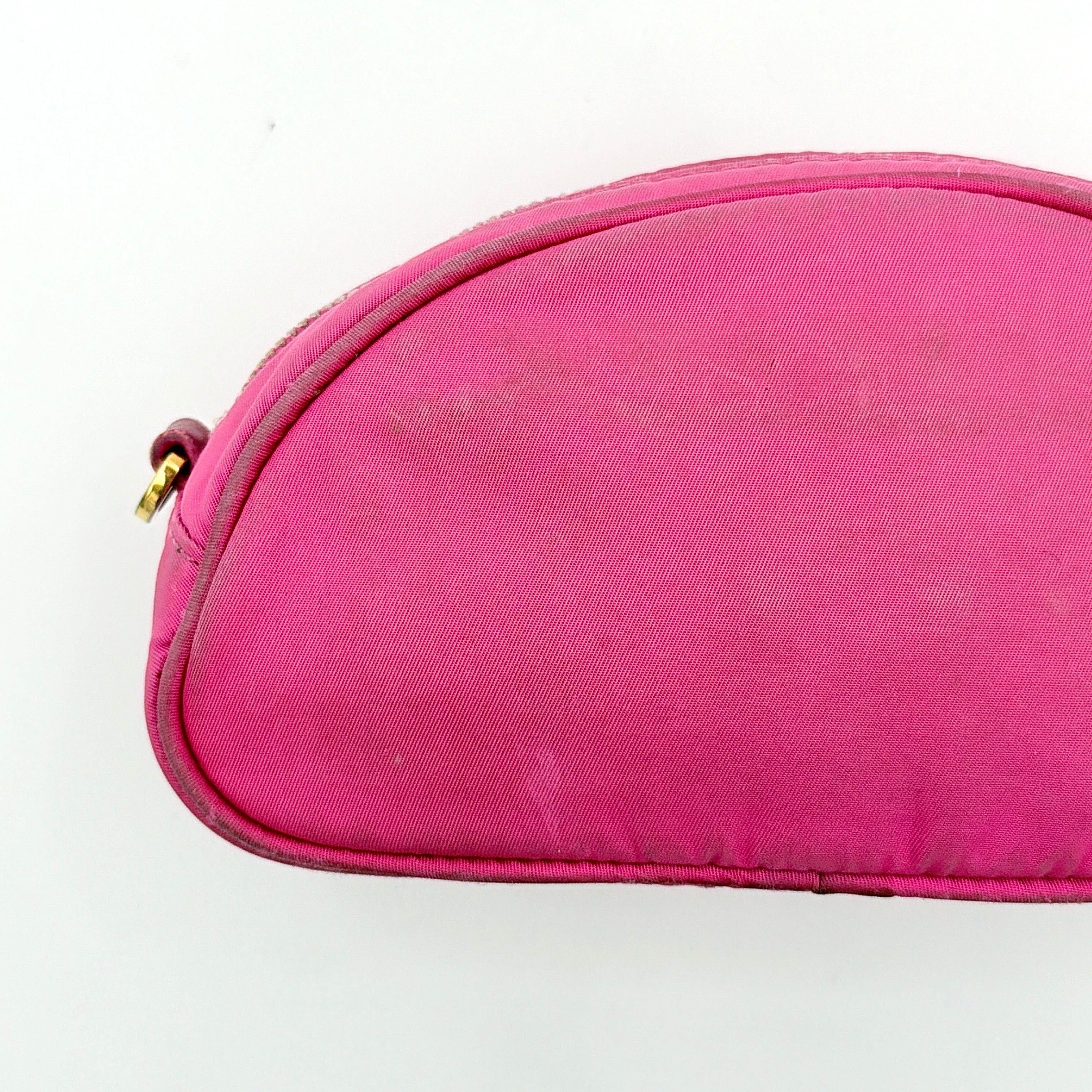 Prada Tessuto Nylon Pouch in vibrant pink with gold-tone hardware and triangle logo, showing visible wear on the exterior.