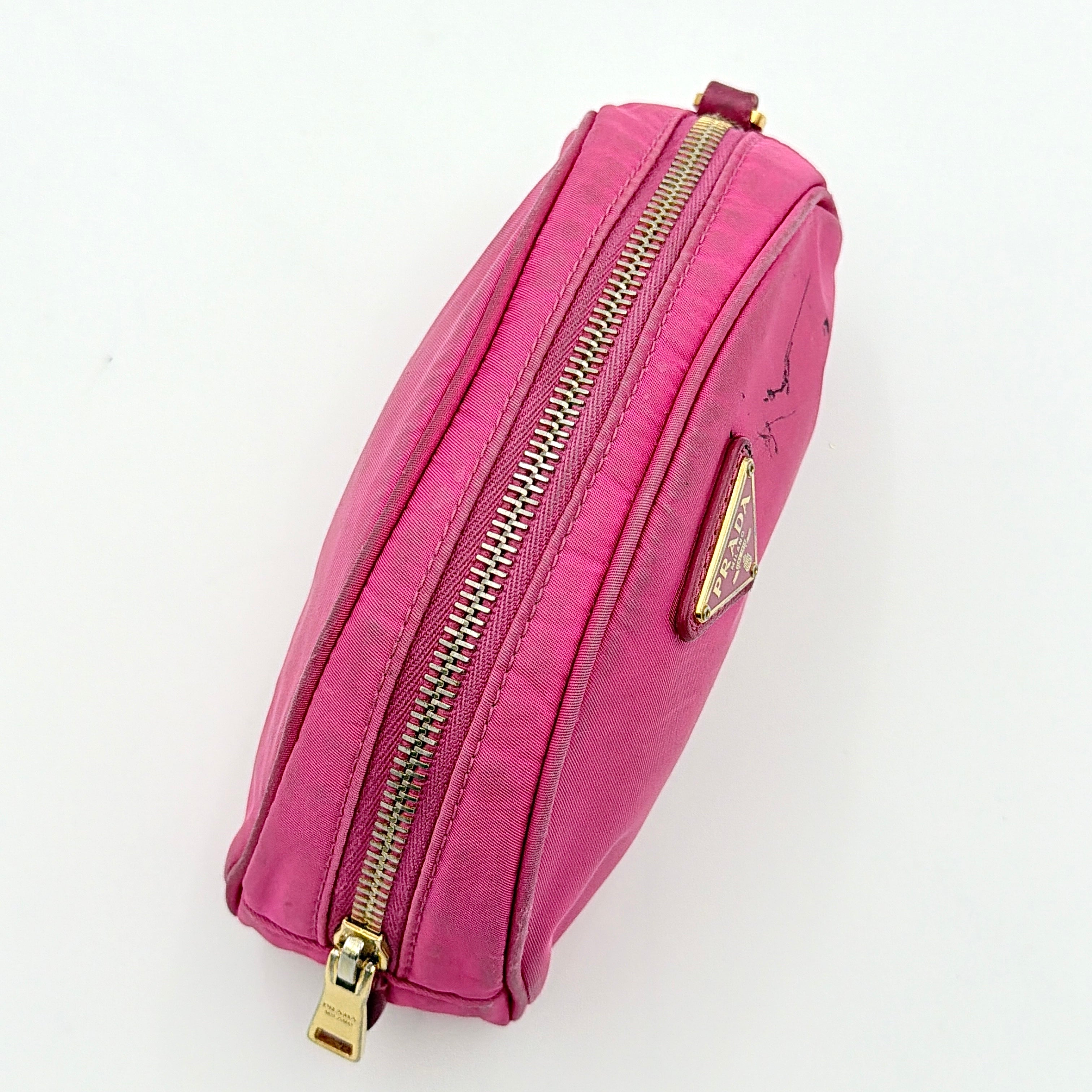 Prada Tessuto Nylon Pouch in vibrant pink with gold-tone hardware and triangle logo, showing visible wear on the exterior.